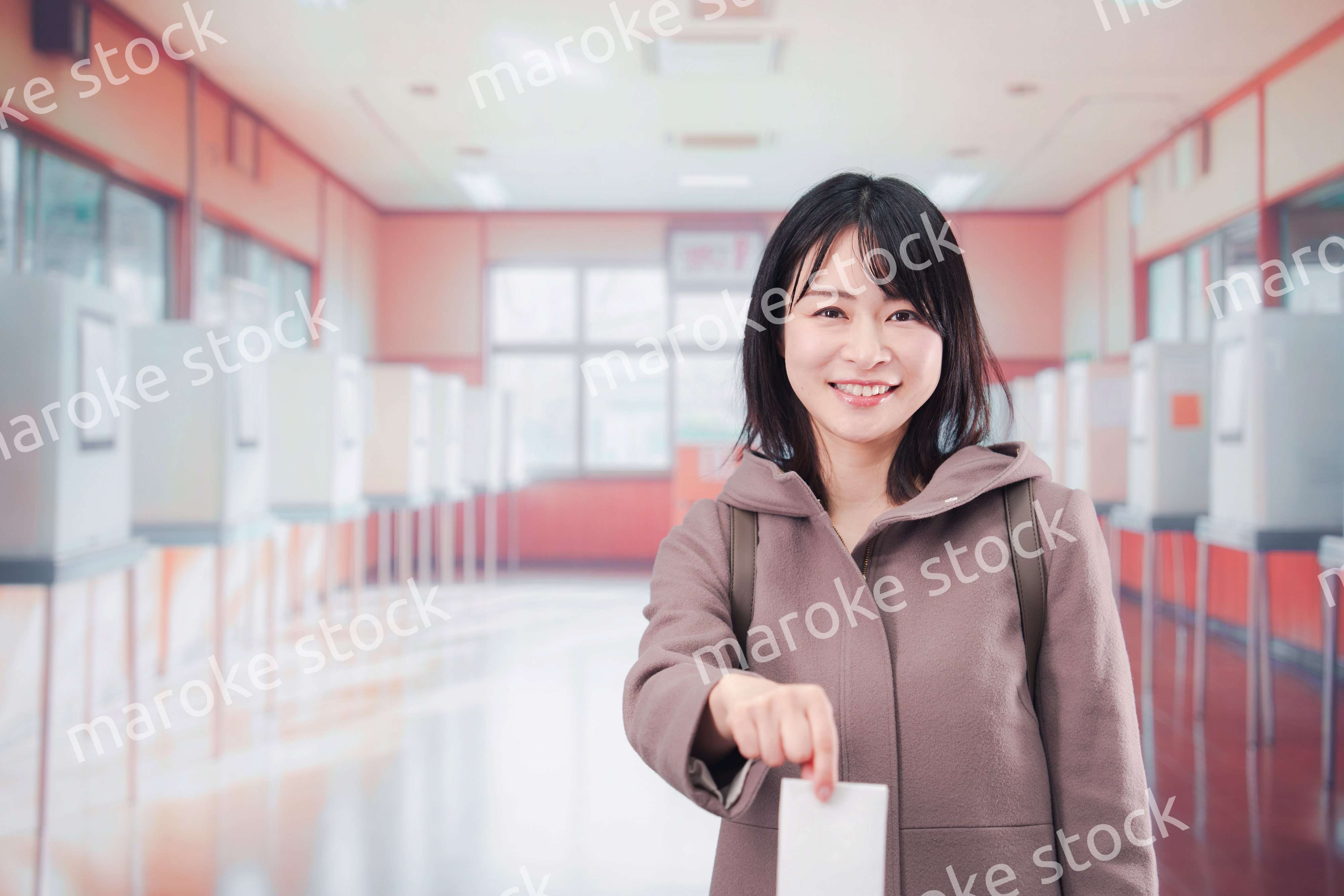 投票所で選挙の投票をする女性の有権者