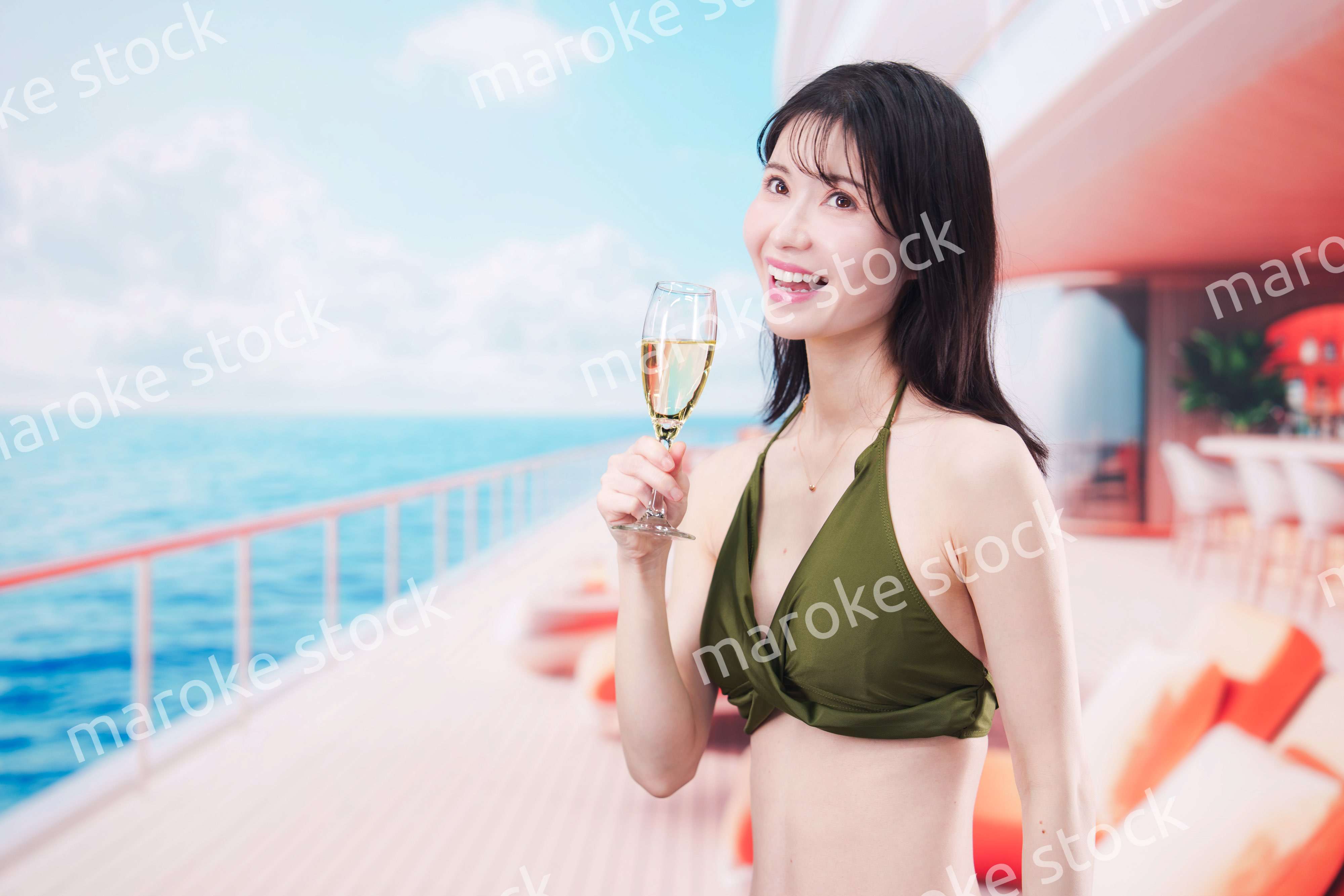 クルーズ船で水着を着てスパークリングワインを飲む若い女性