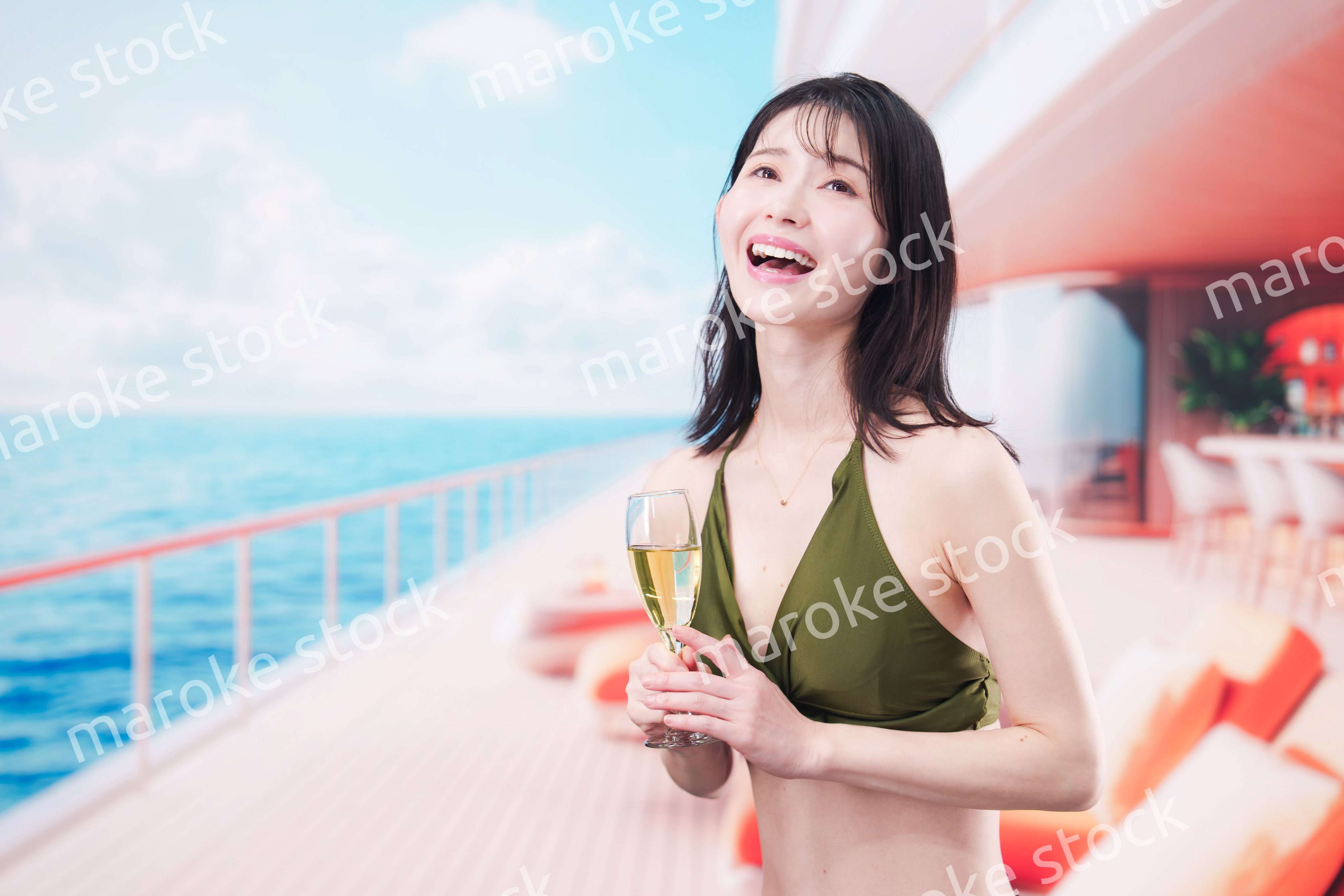 クルーズ船で水着を着てスパークリングワインを飲む若い女性