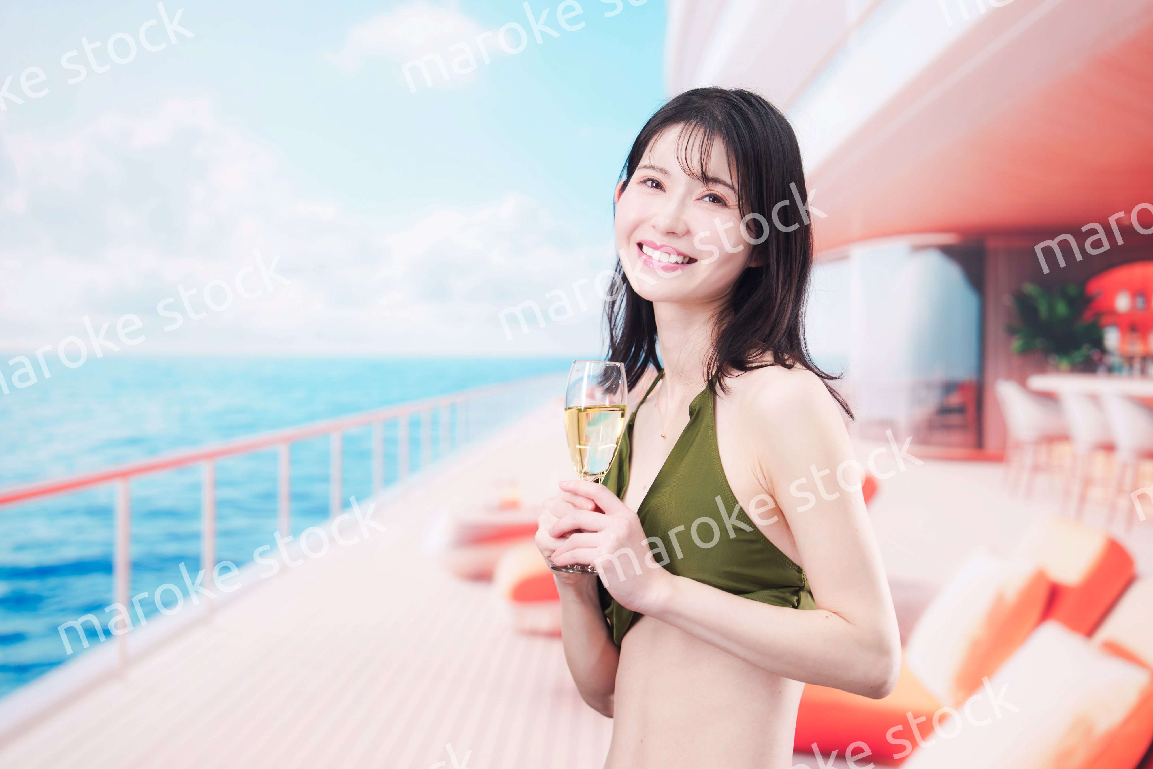 クルーズ船で水着を着てスパークリングワインを飲む若い女性