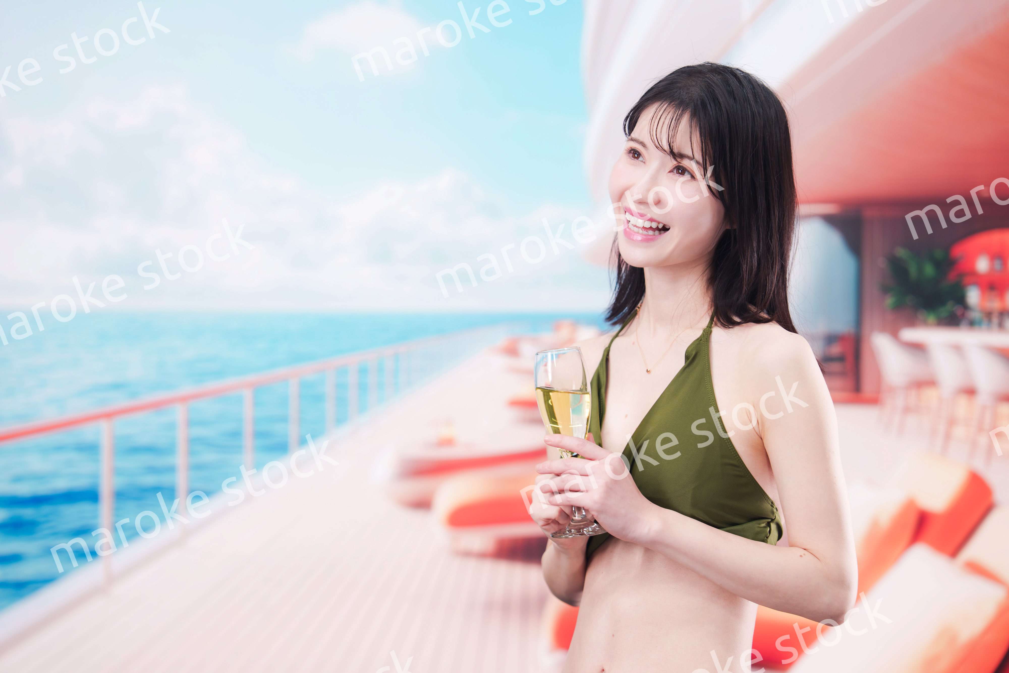 クルーズ船で水着を着てスパークリングワインを飲む若い女性