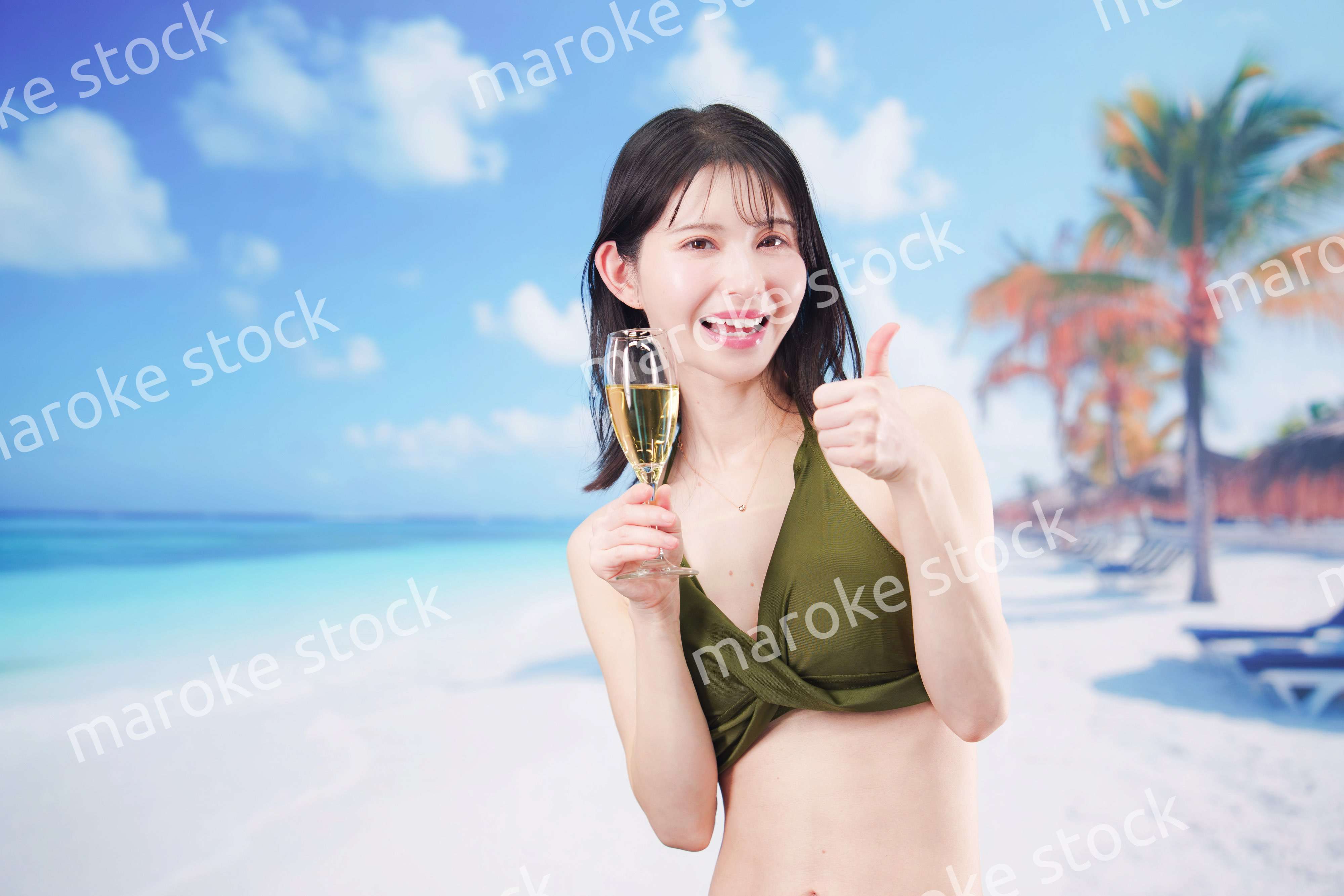 真夏のビーチでスパークリングワインを飲む水着を着た若い女性