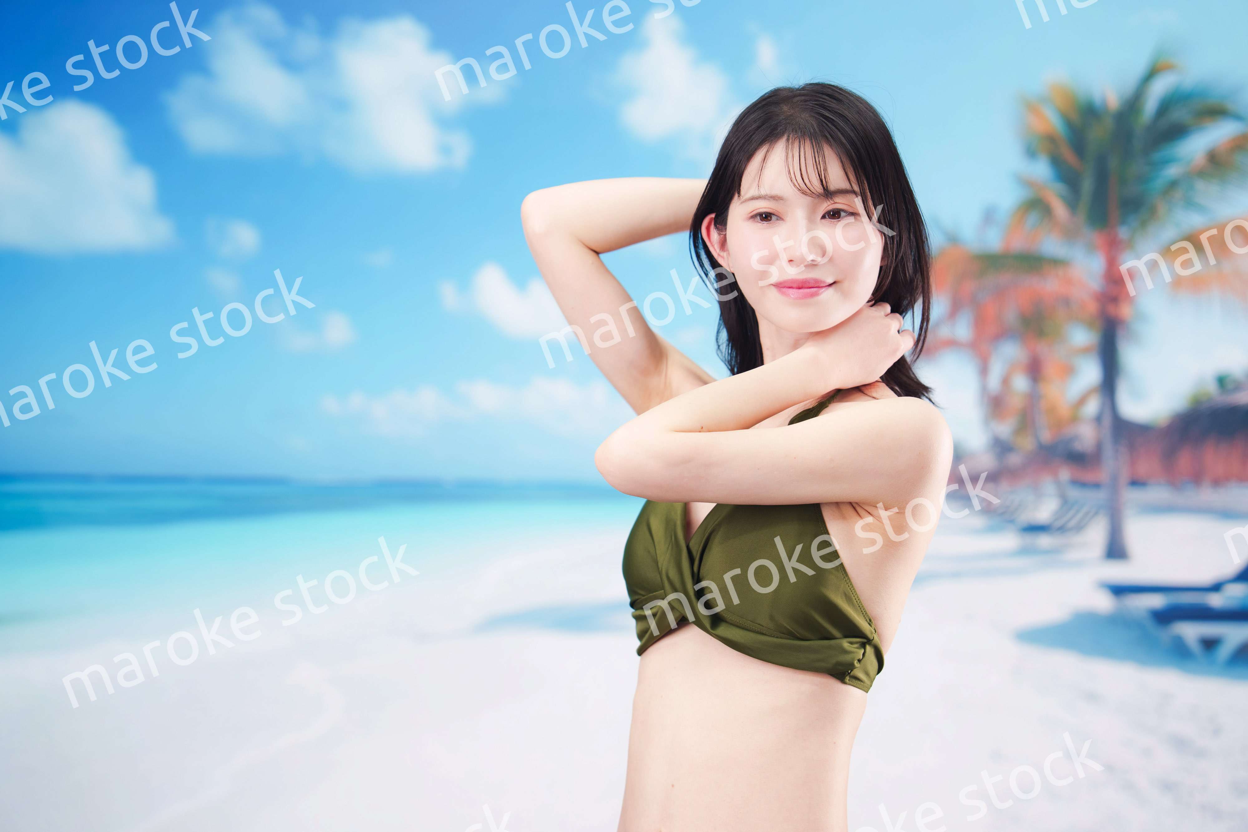 真夏のビーチでポーズを決める若い女性