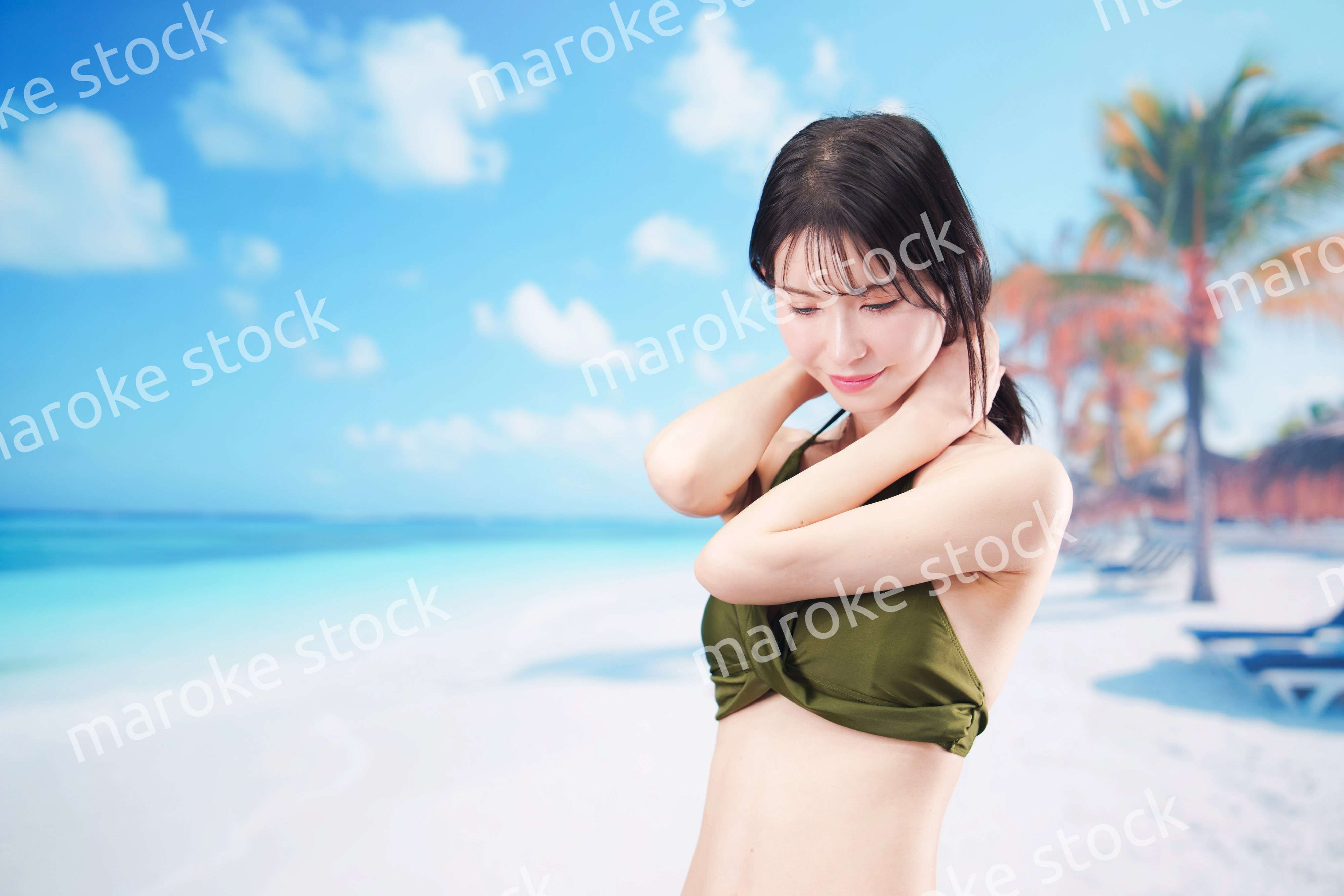 真夏のビーチでポーズを決める若い女性