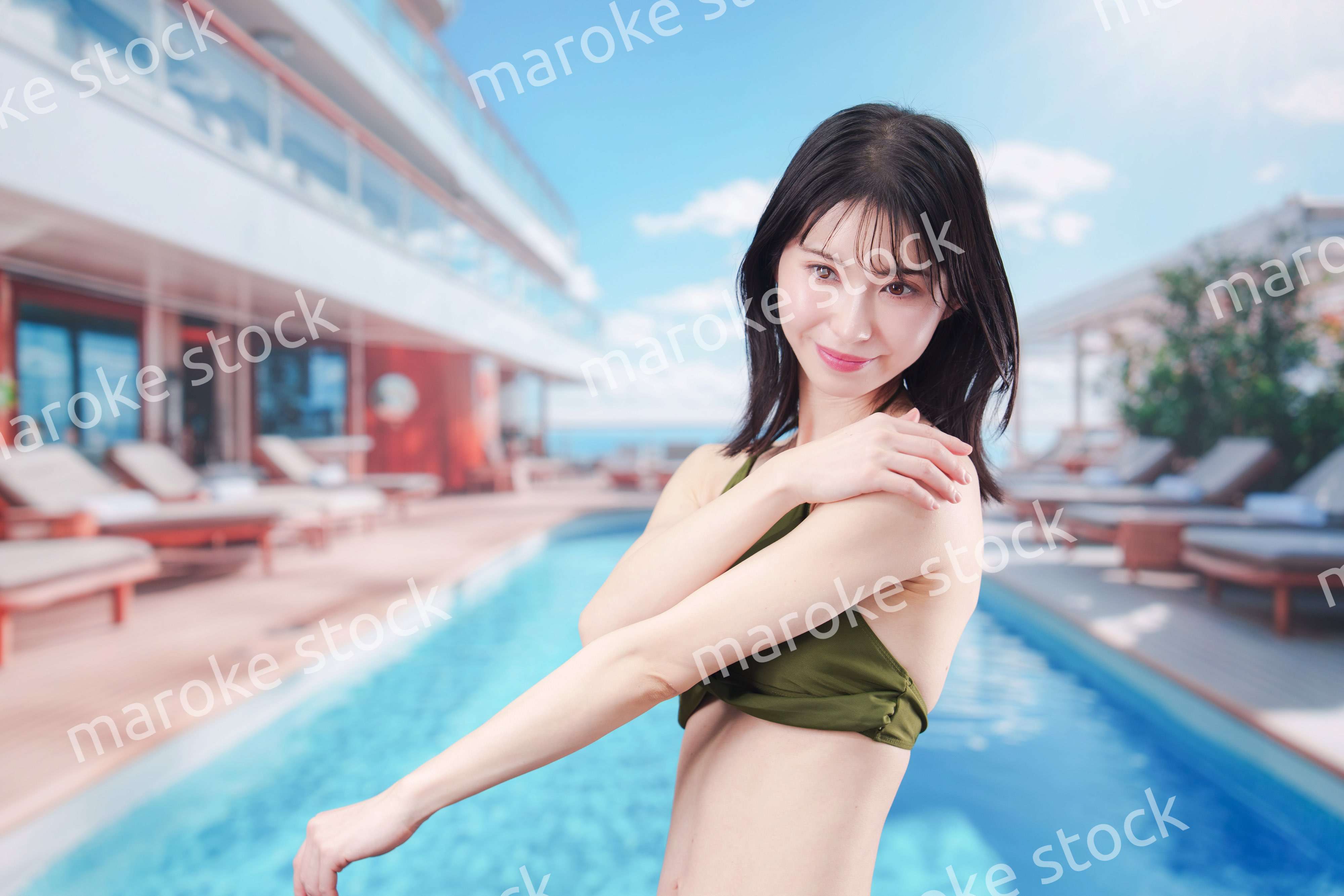 真夏のリゾートで日焼け止めクリームを塗る若い女性