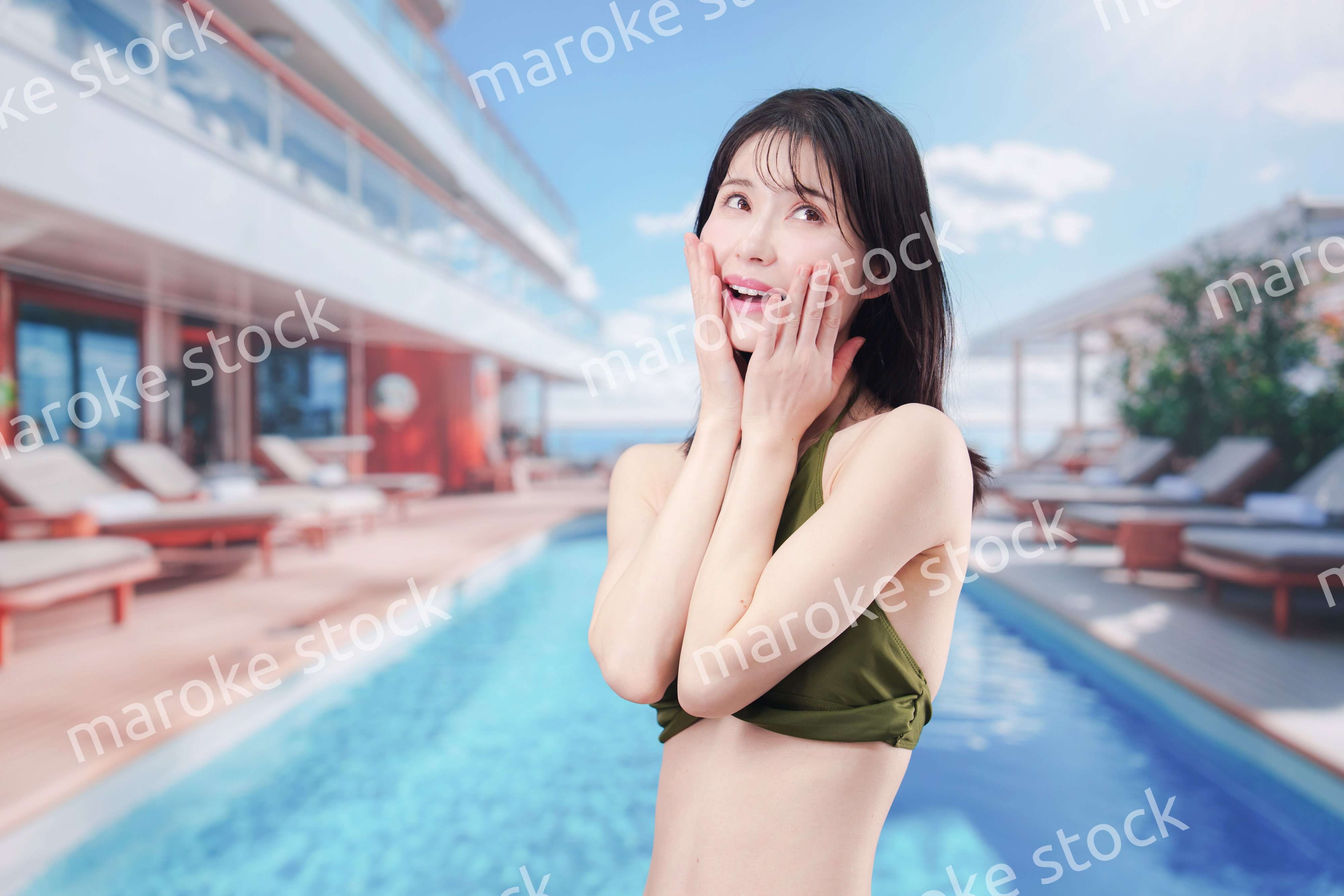 太陽が降り注ぐリゾートで顔に日焼け止めを塗る水着姿の女性