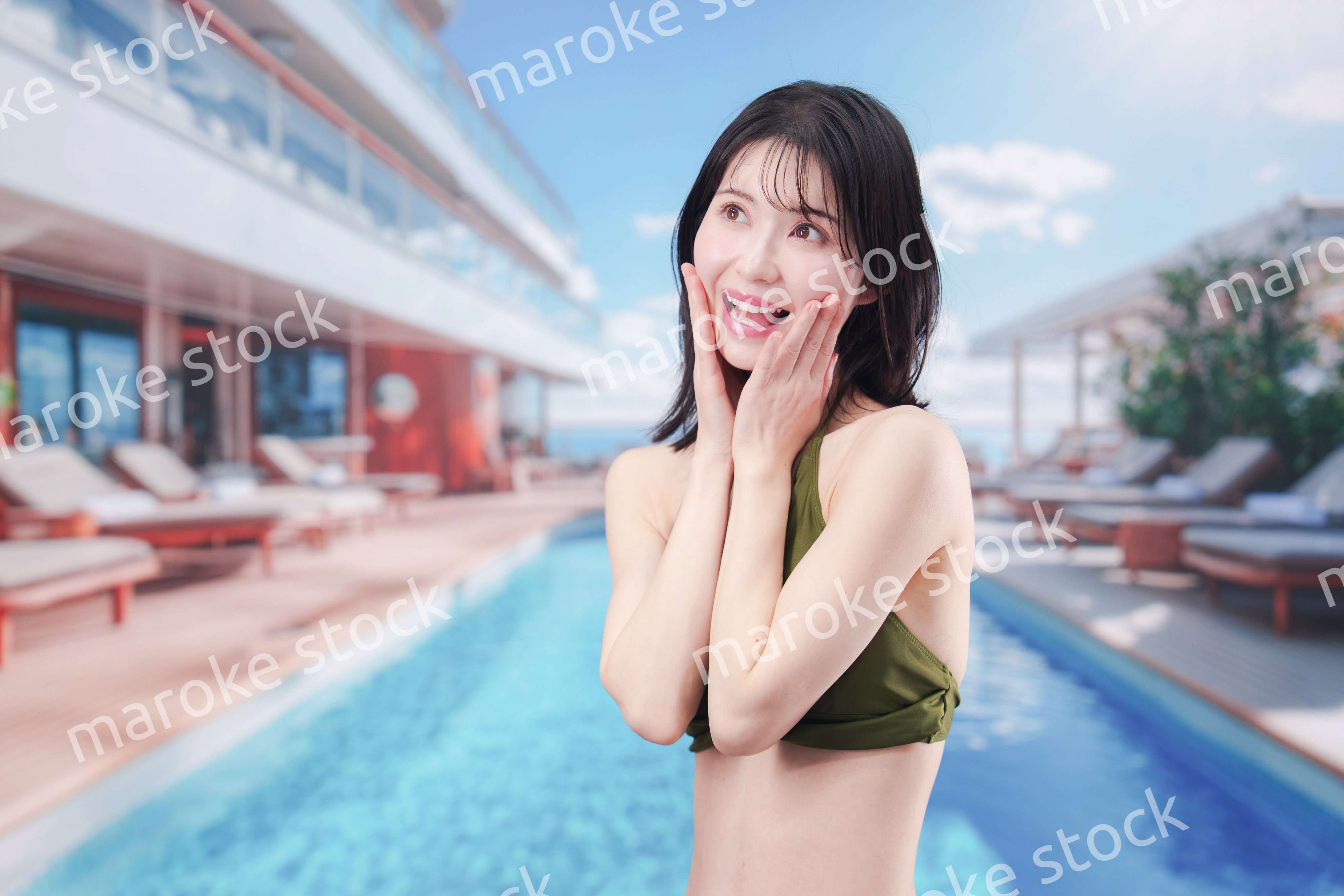 太陽が降り注ぐリゾートで顔に日焼け止めを塗る水着姿の女性