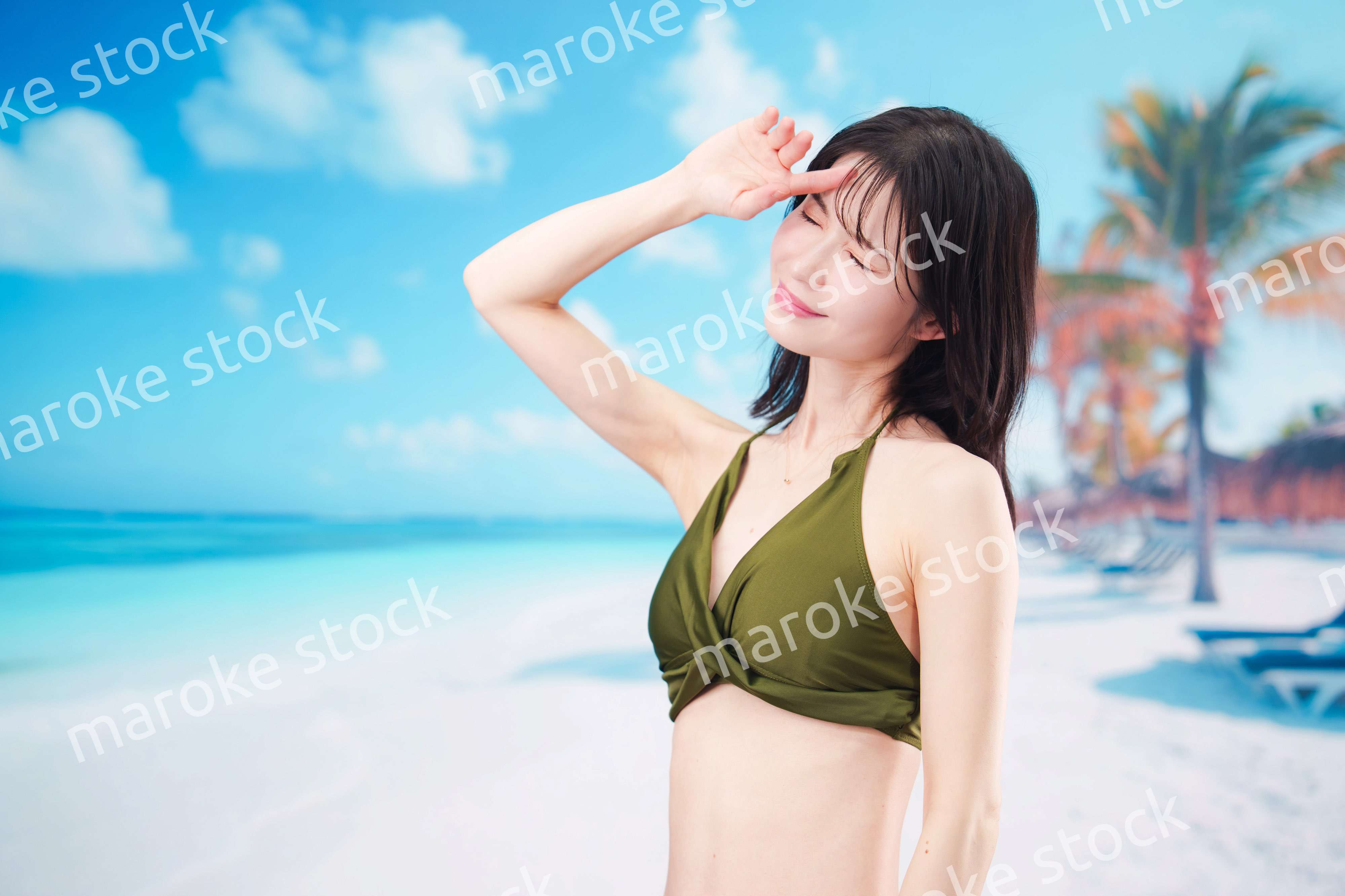 青空のビーチで水着を着た若い女性