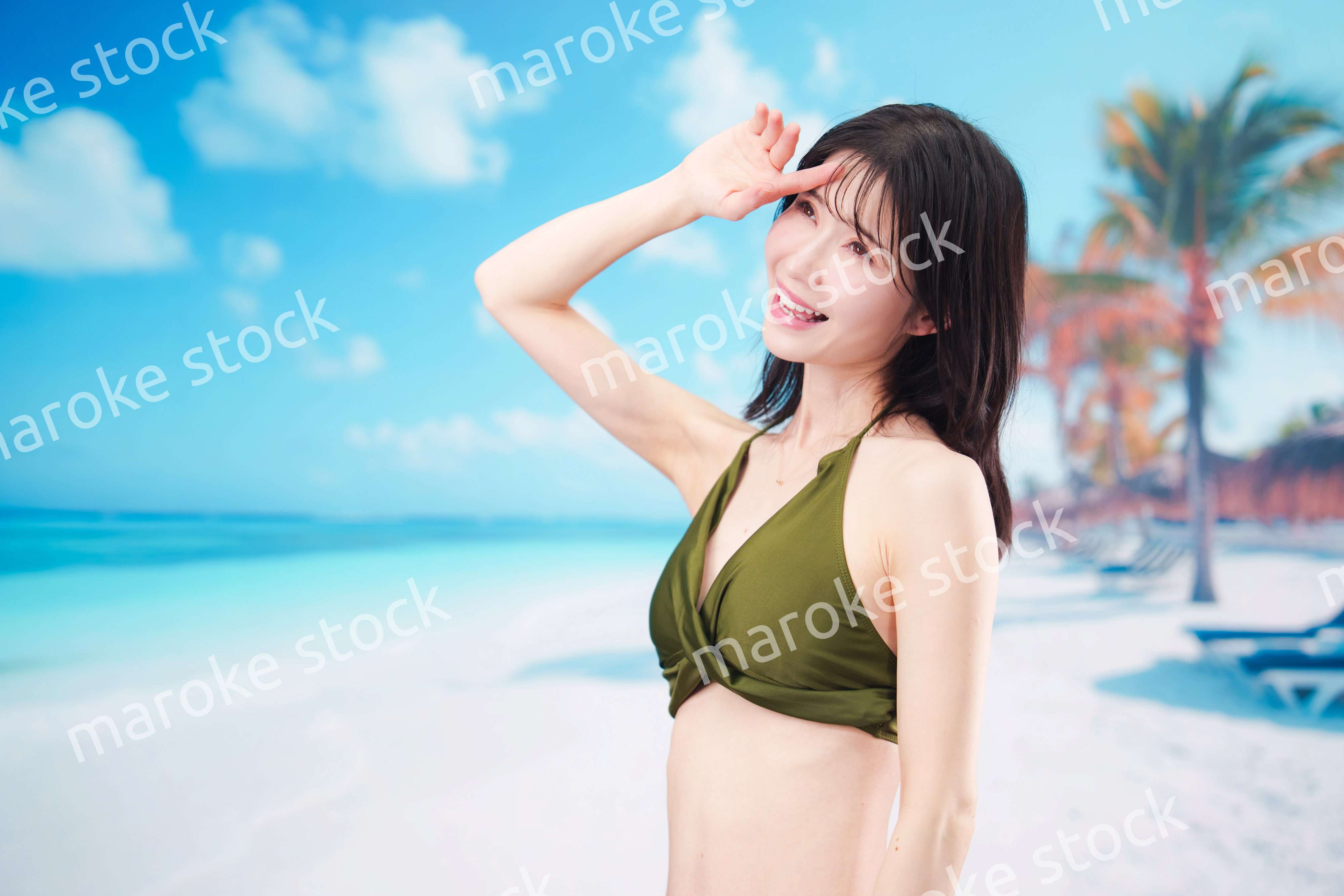 青空のビーチで水着を着た若い女性