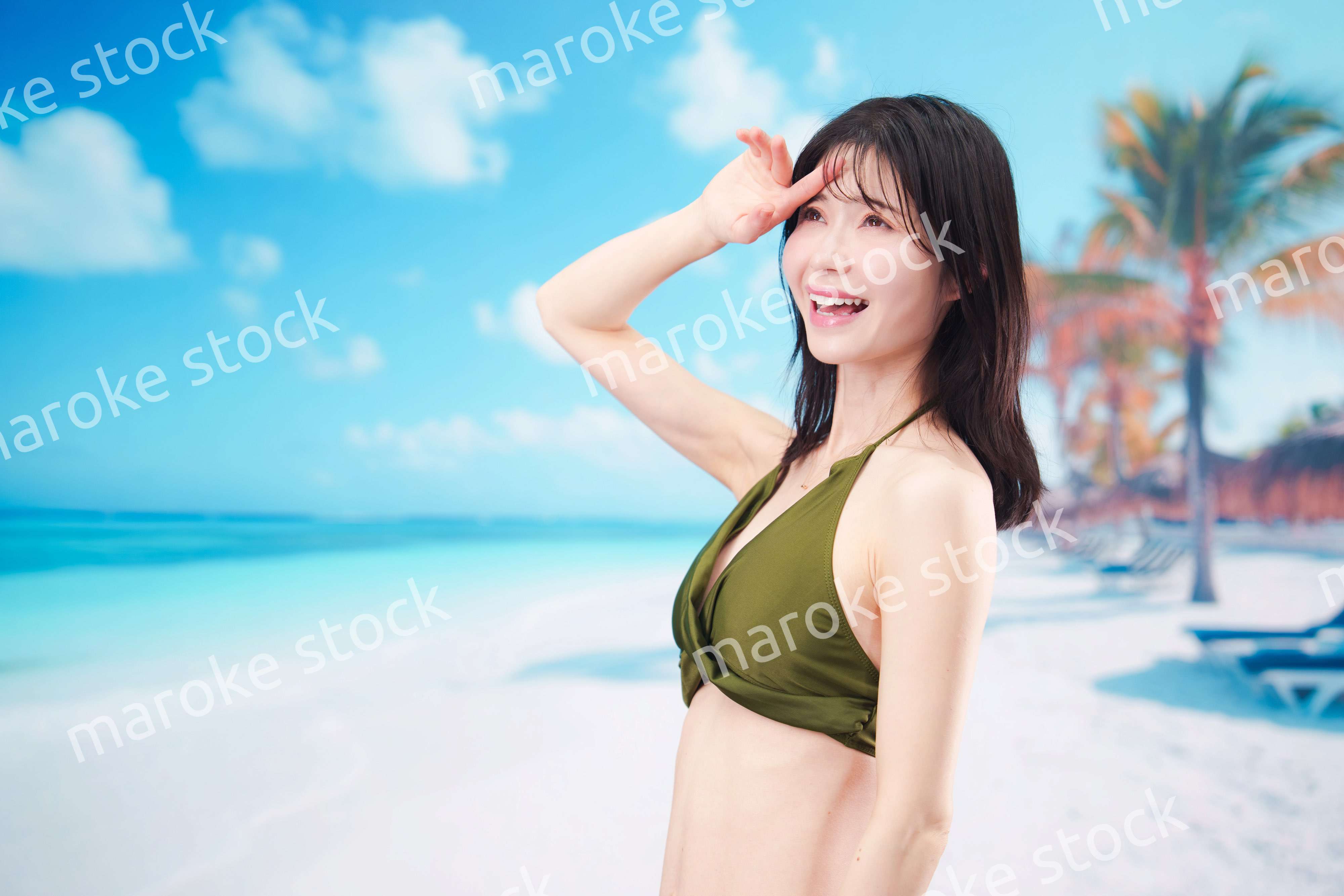 青空のビーチで水着を着た若い女性