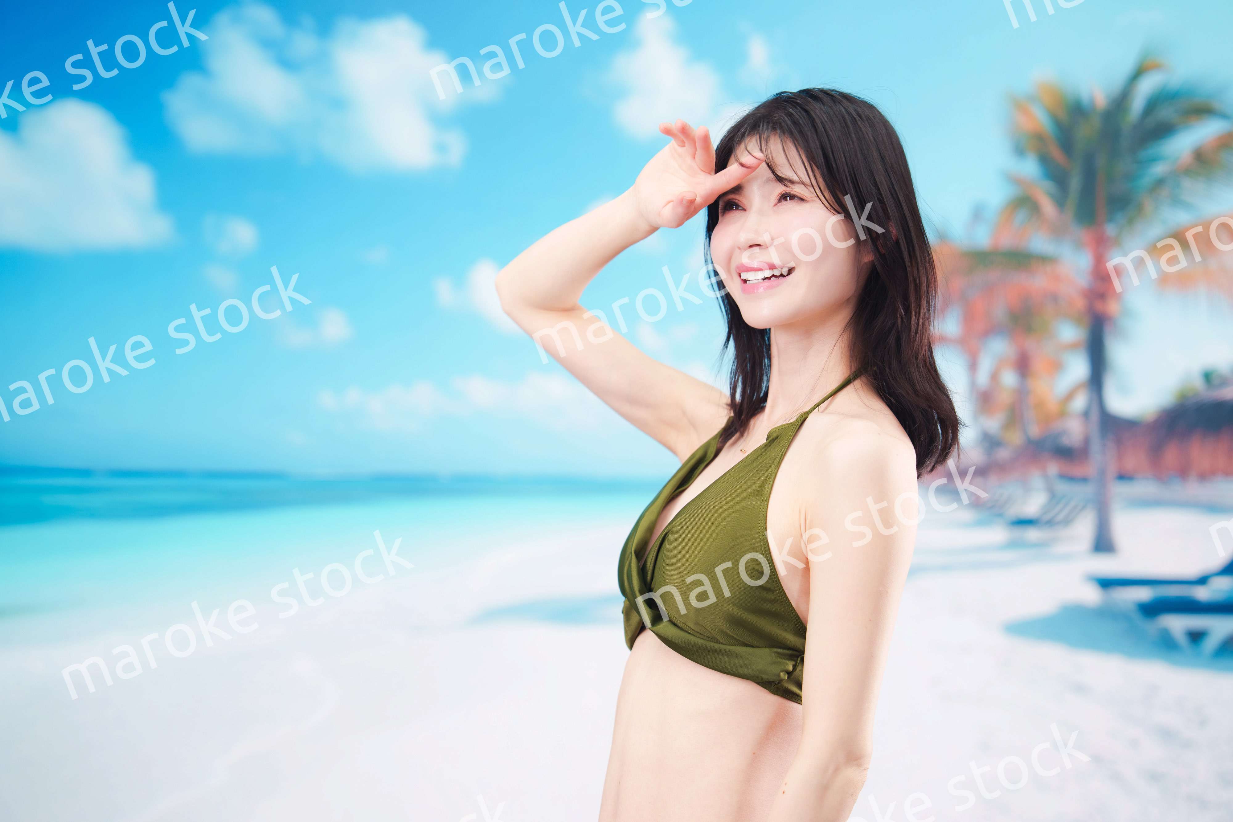 青空のビーチで水着を着た若い女性