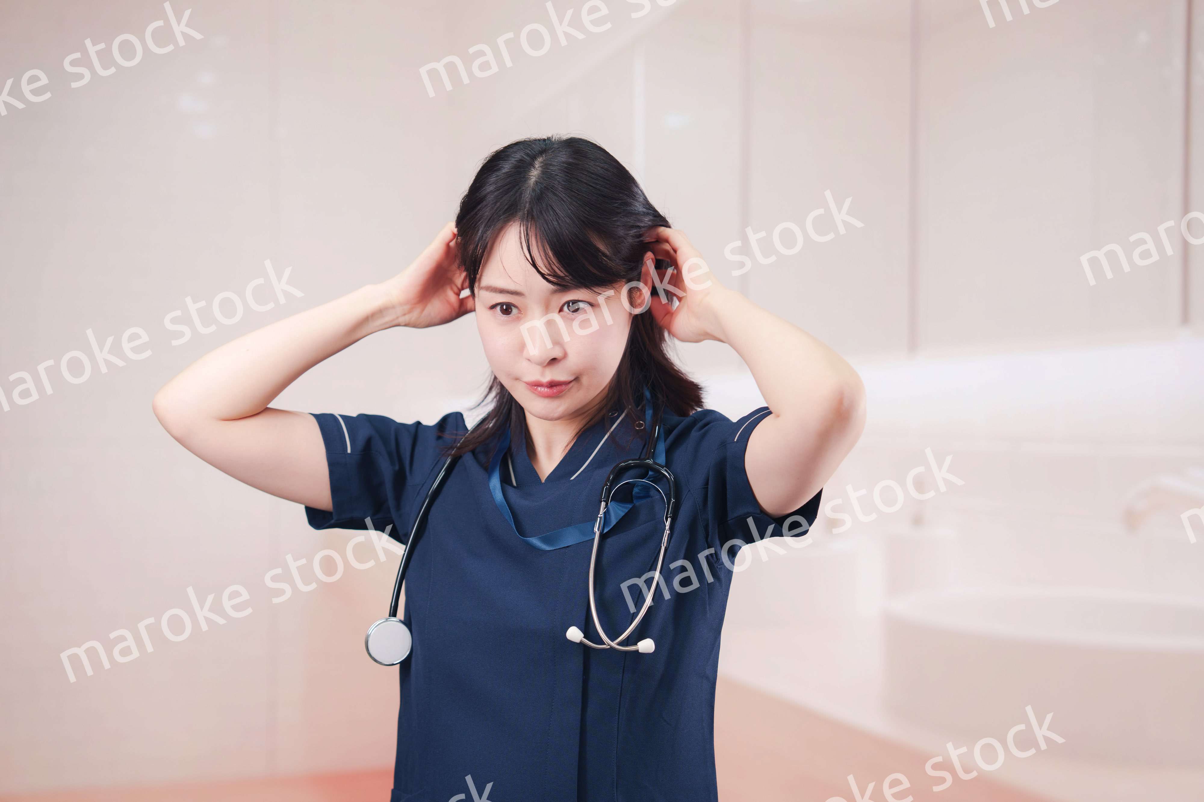 化粧室で身だしなみを整える医療従事者の女性