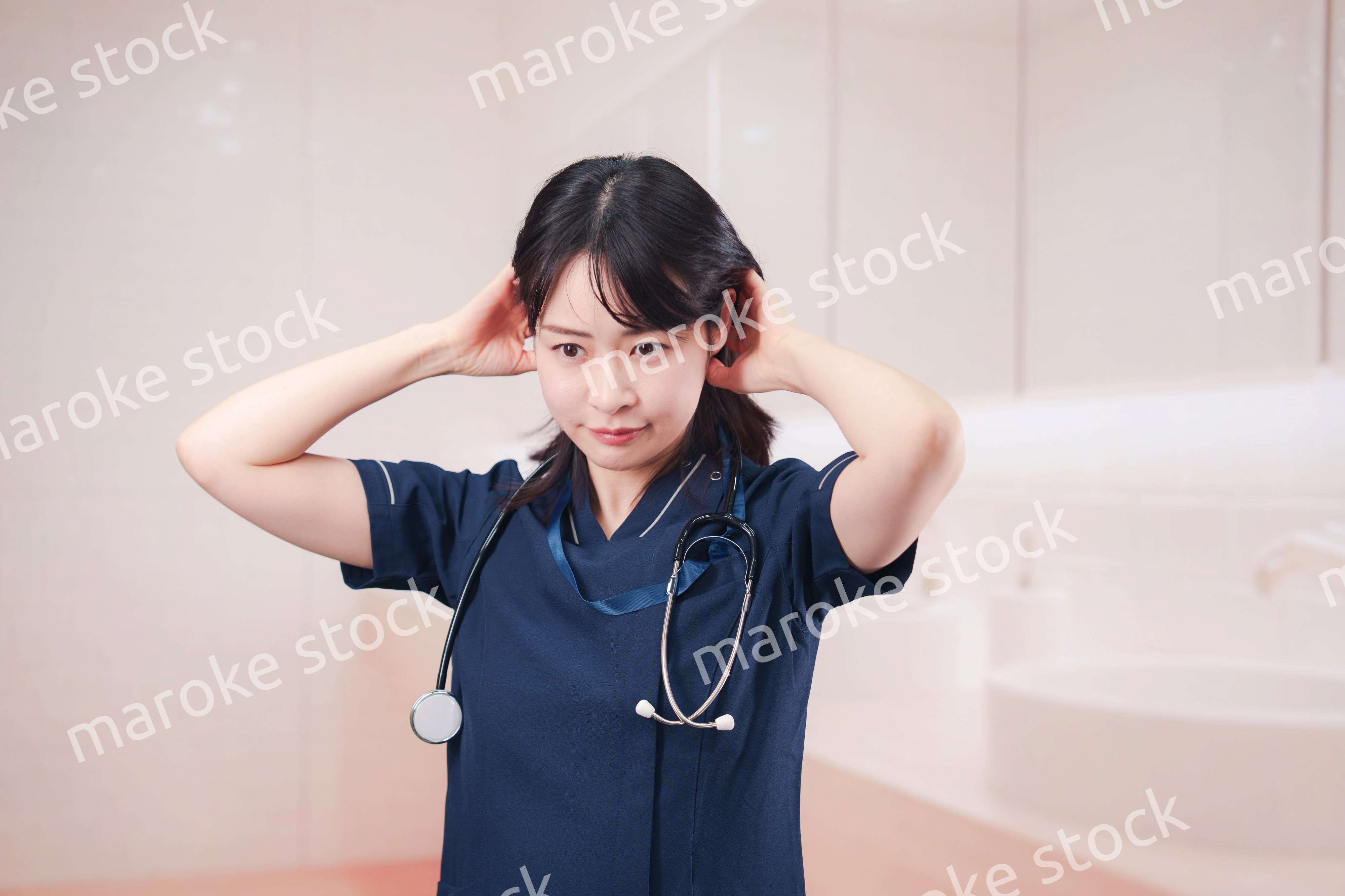 化粧室で身だしなみを整える医療従事者の女性