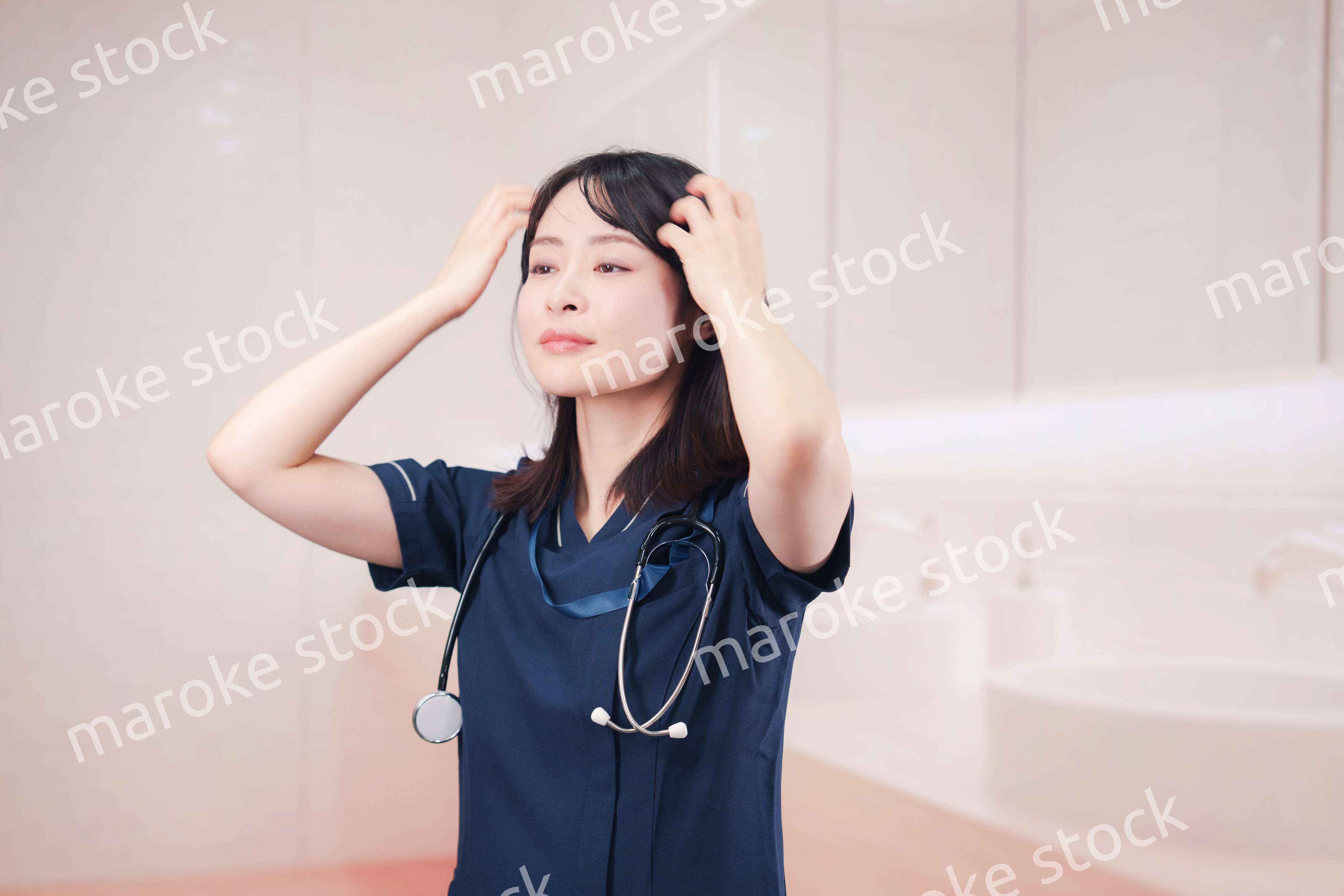 化粧室で身だしなみを整える医療従事者の女性