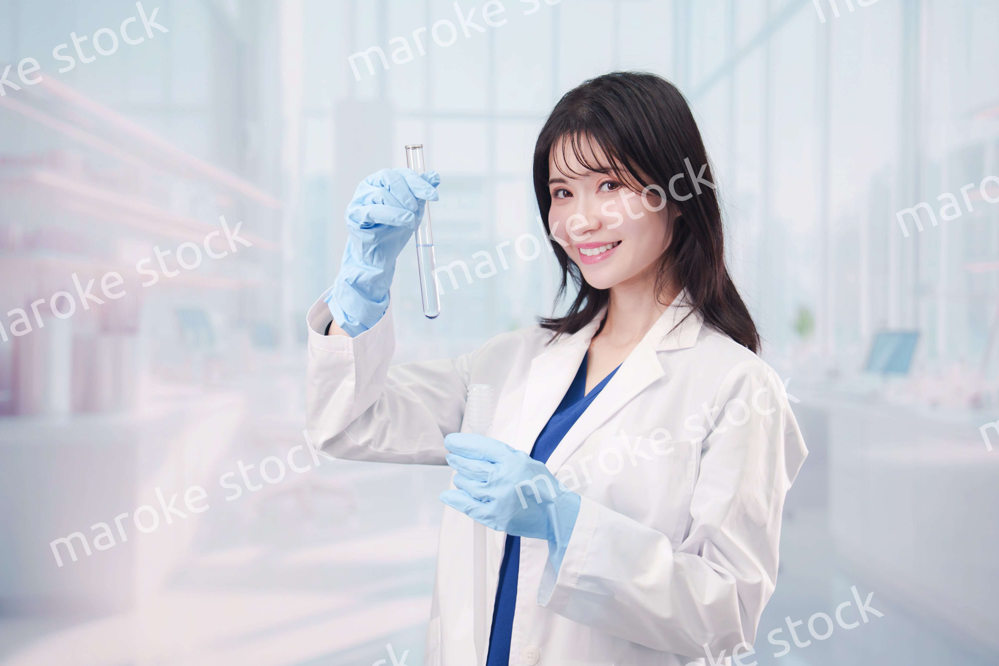 白衣を着て実験をする女性の研究者