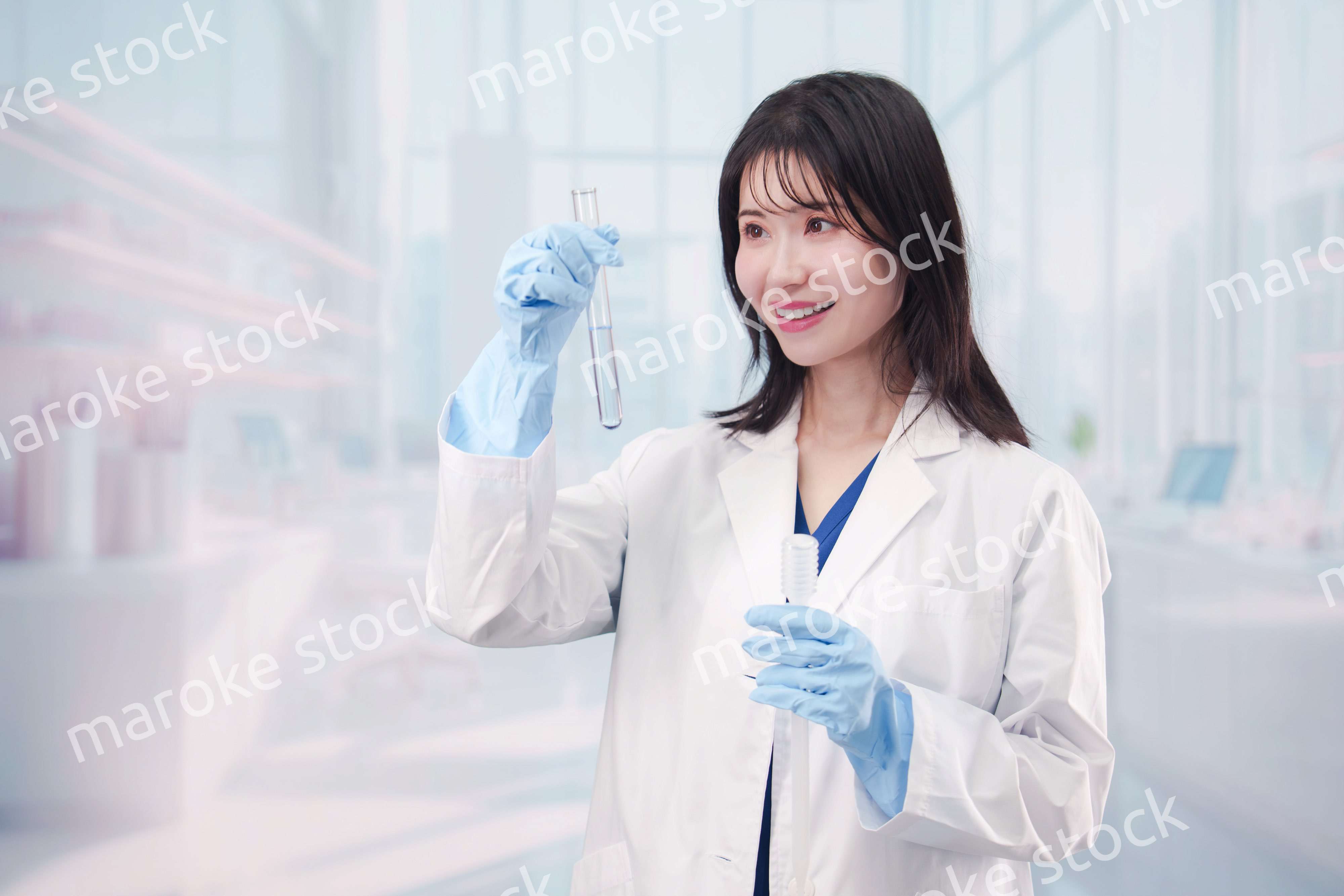 白衣を着て実験をする女性の研究者