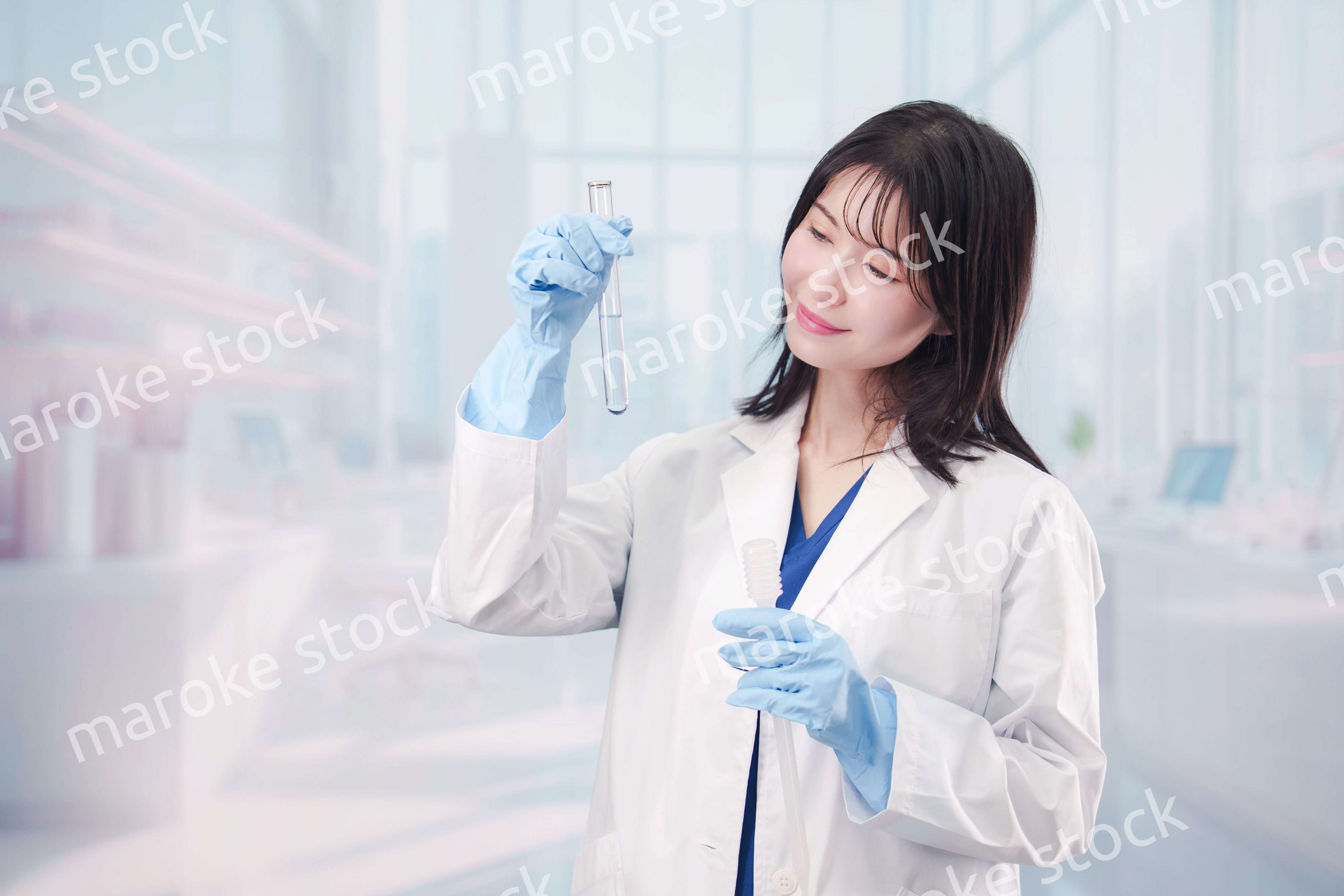 白衣を着て実験をする女性の研究者