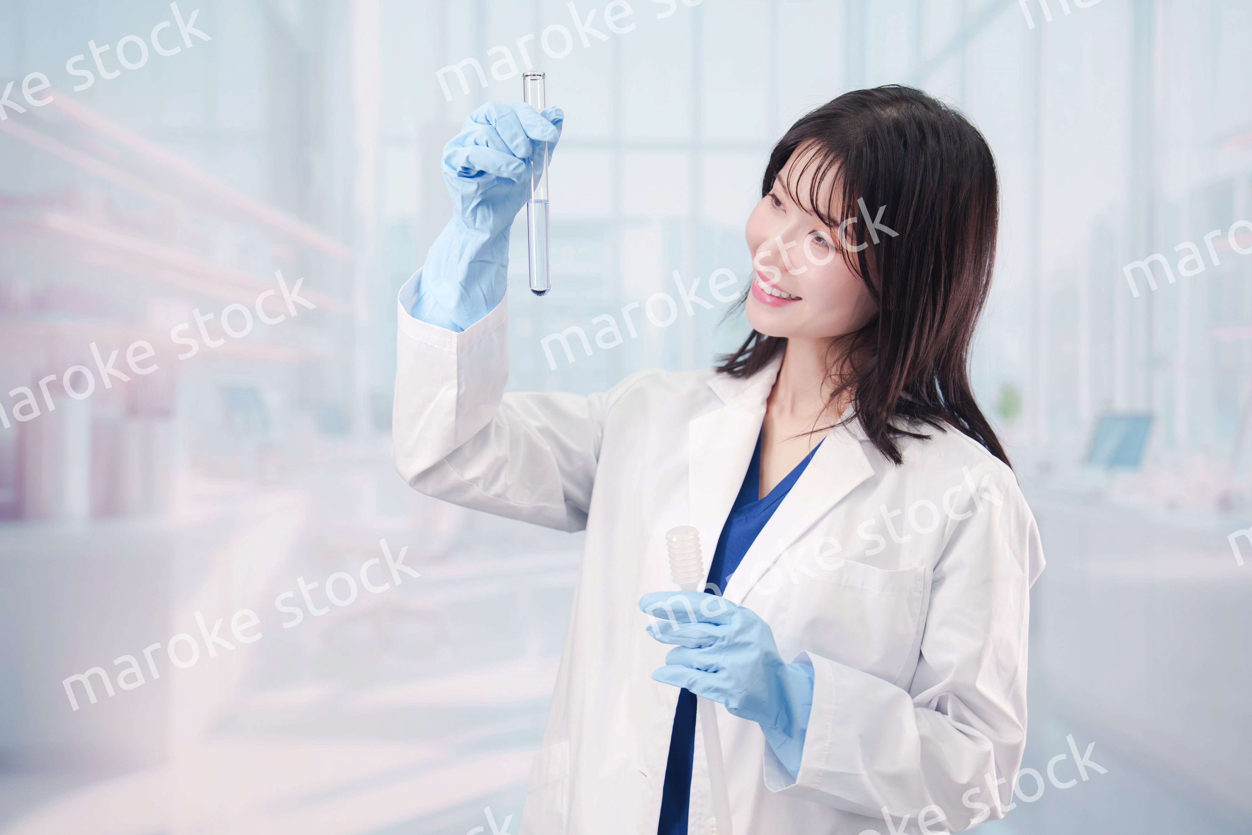 白衣を着て実験をする女性の研究者