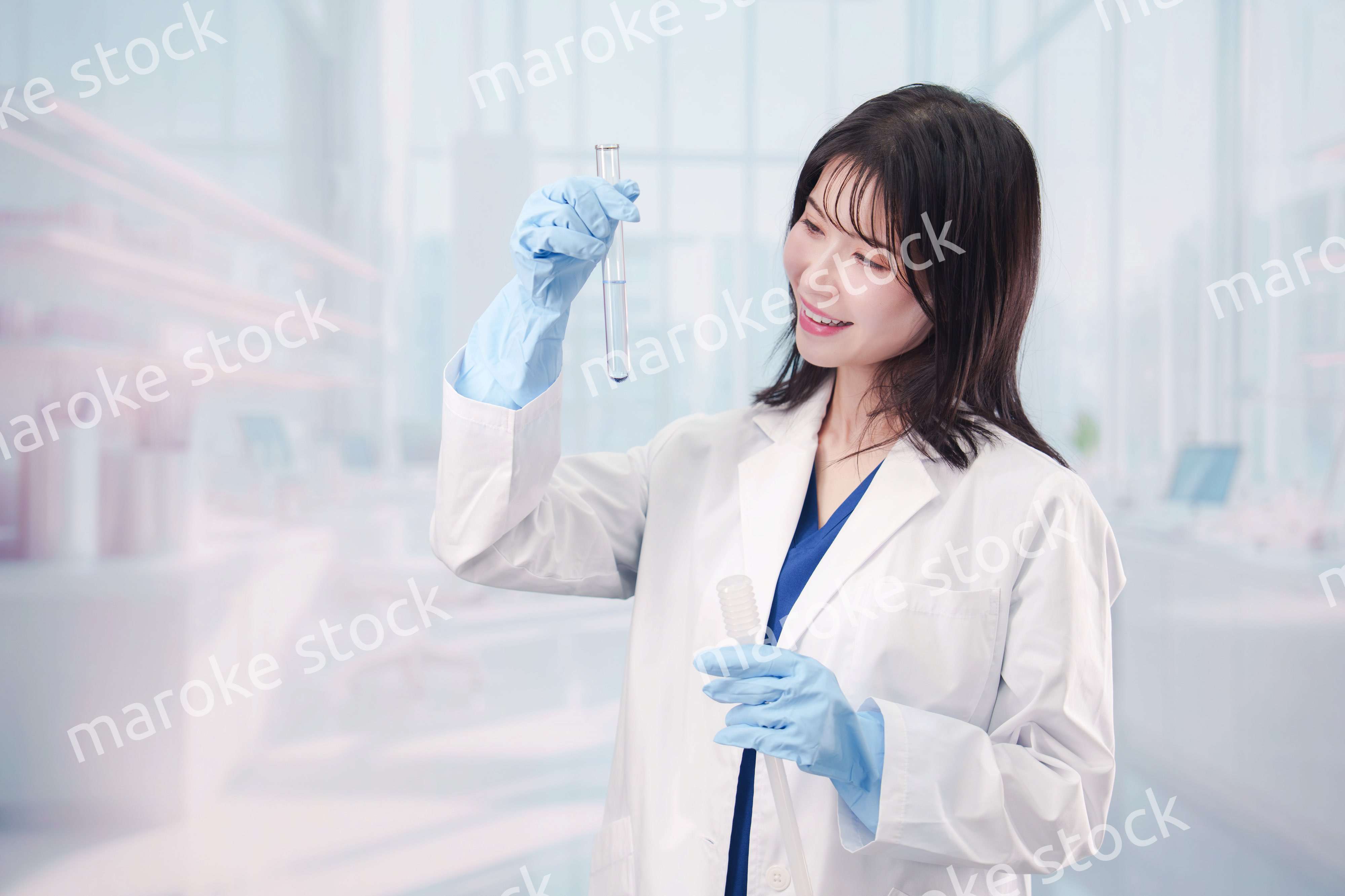 白衣を着て実験をする女性の研究者