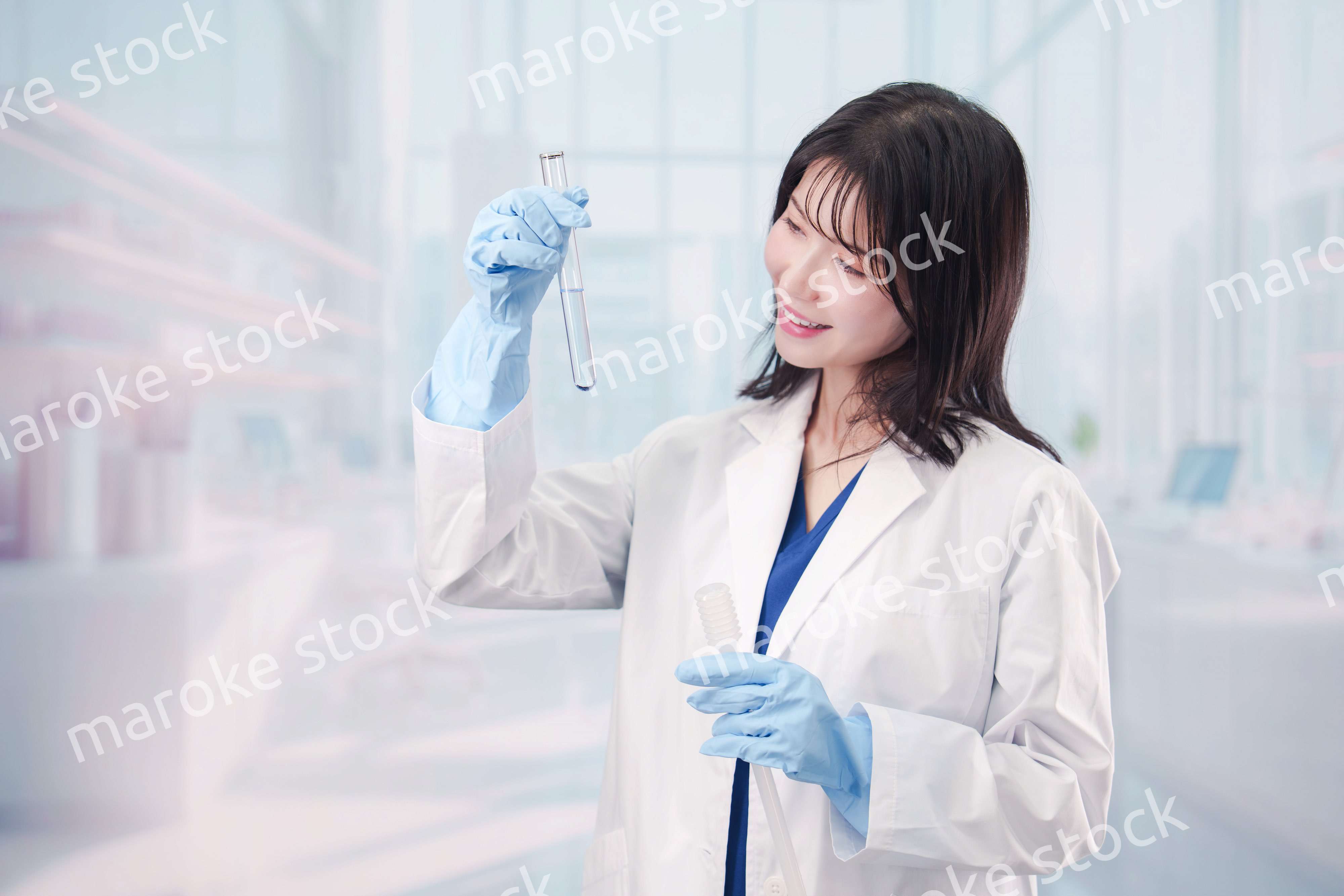 白衣を着て実験をする女性の研究者