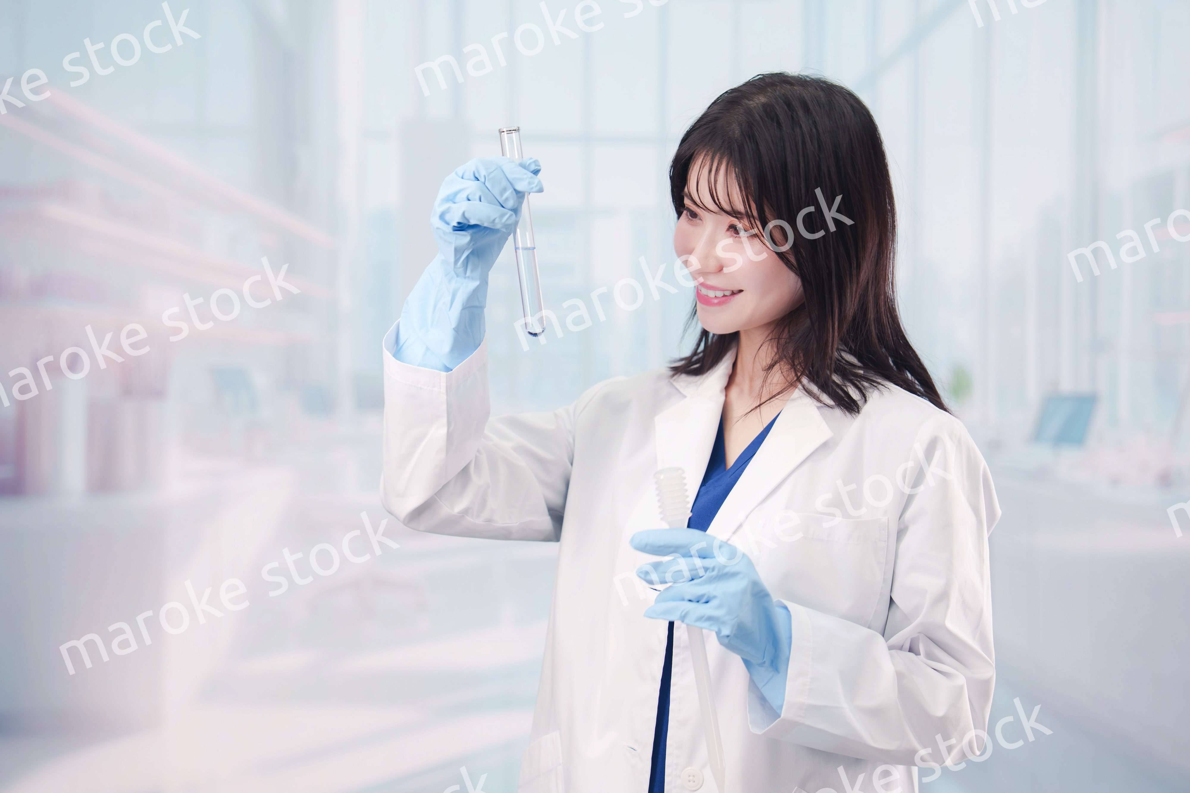 白衣を着て実験をする女性の研究者