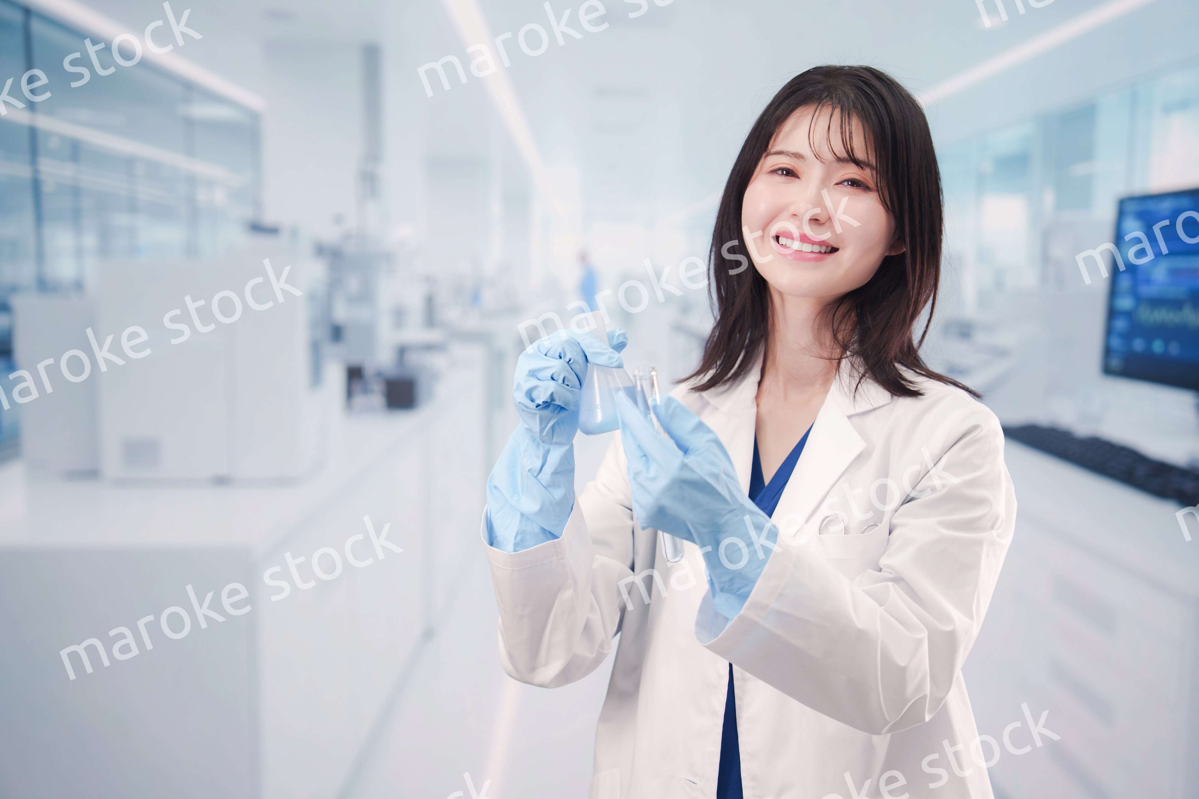 実験室で試験管の薬品を扱う若い女性