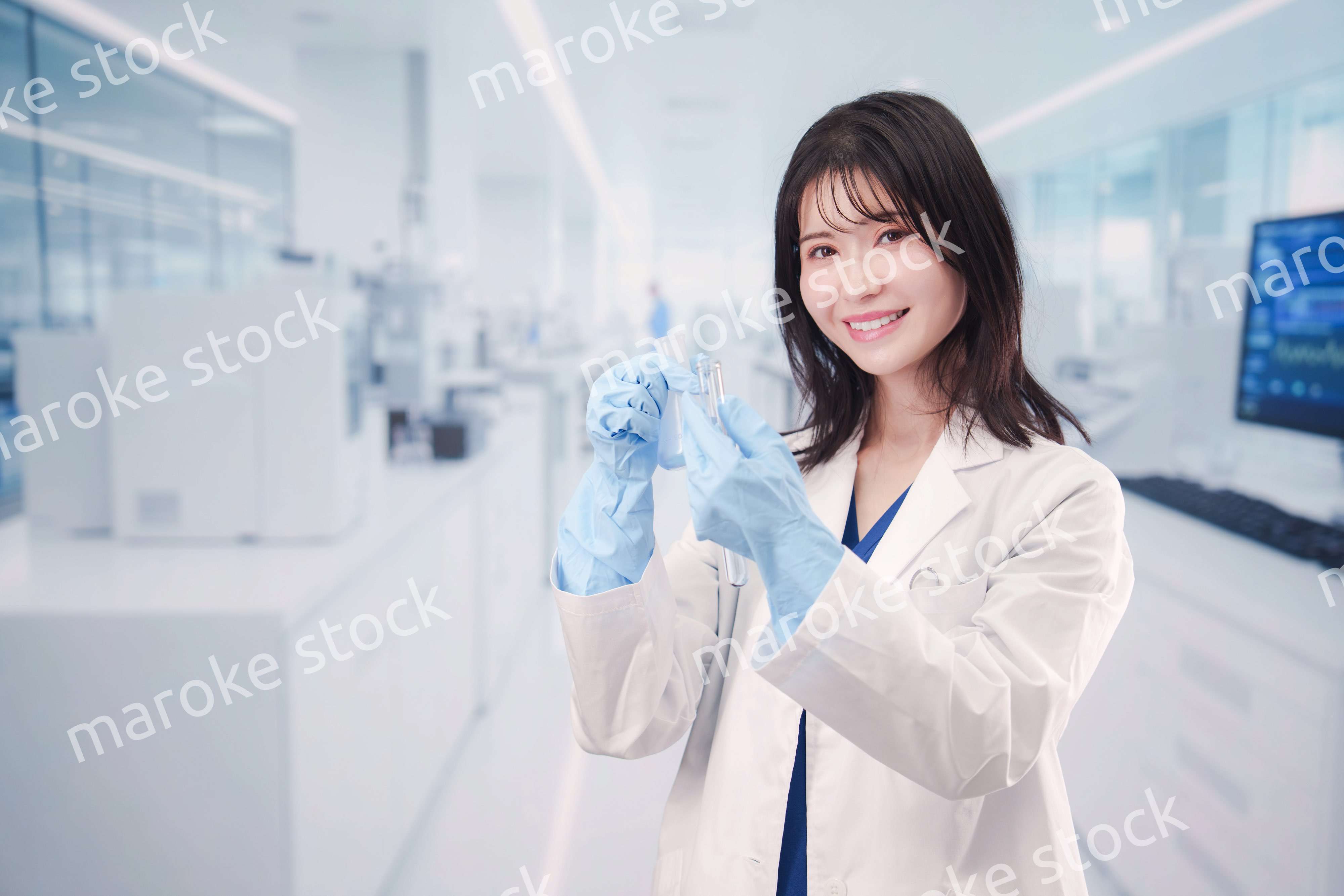 実験室で試験管の薬品を扱う若い女性