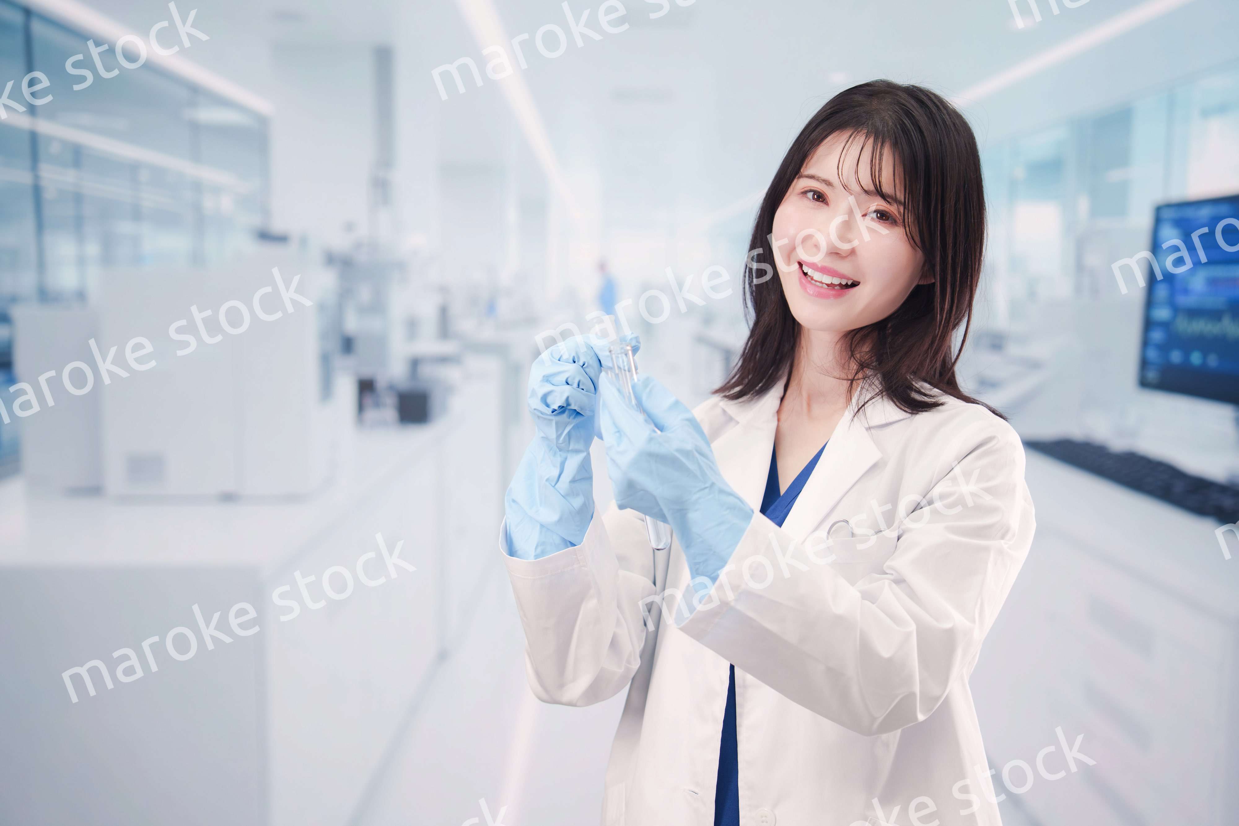 実験室で試験管の薬品を扱う若い女性