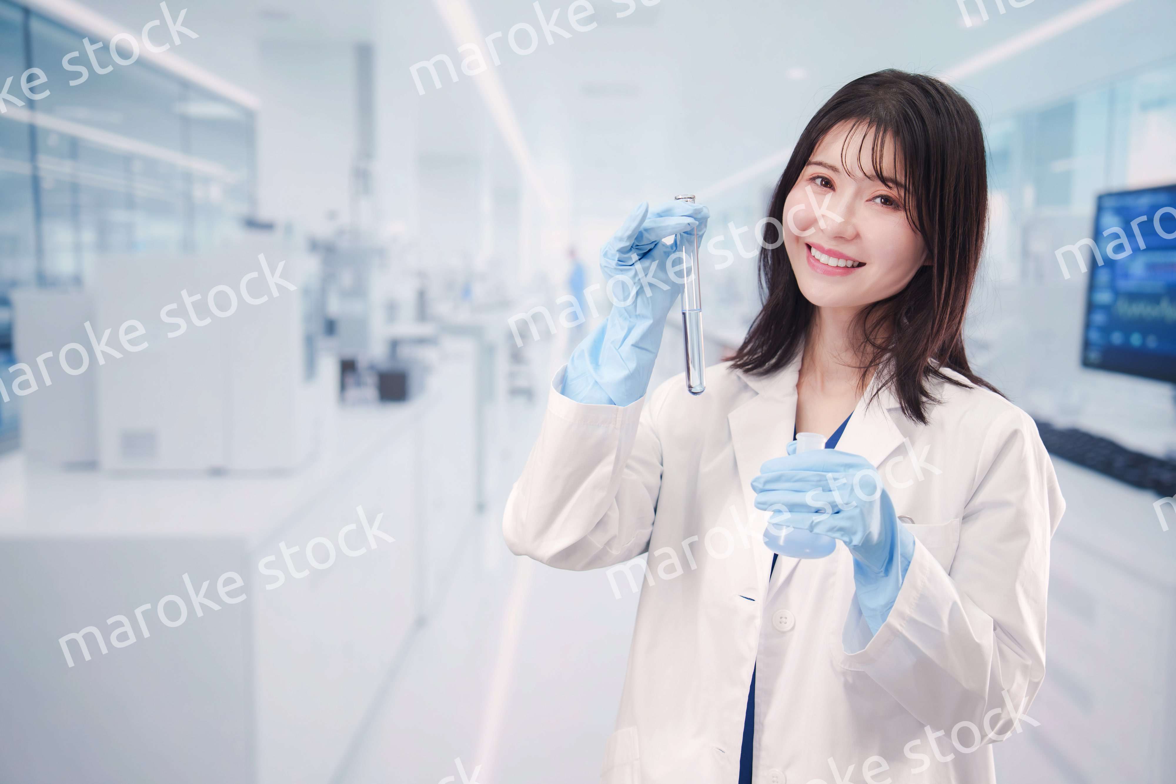 実験室で試験管の薬品を扱う若い女性