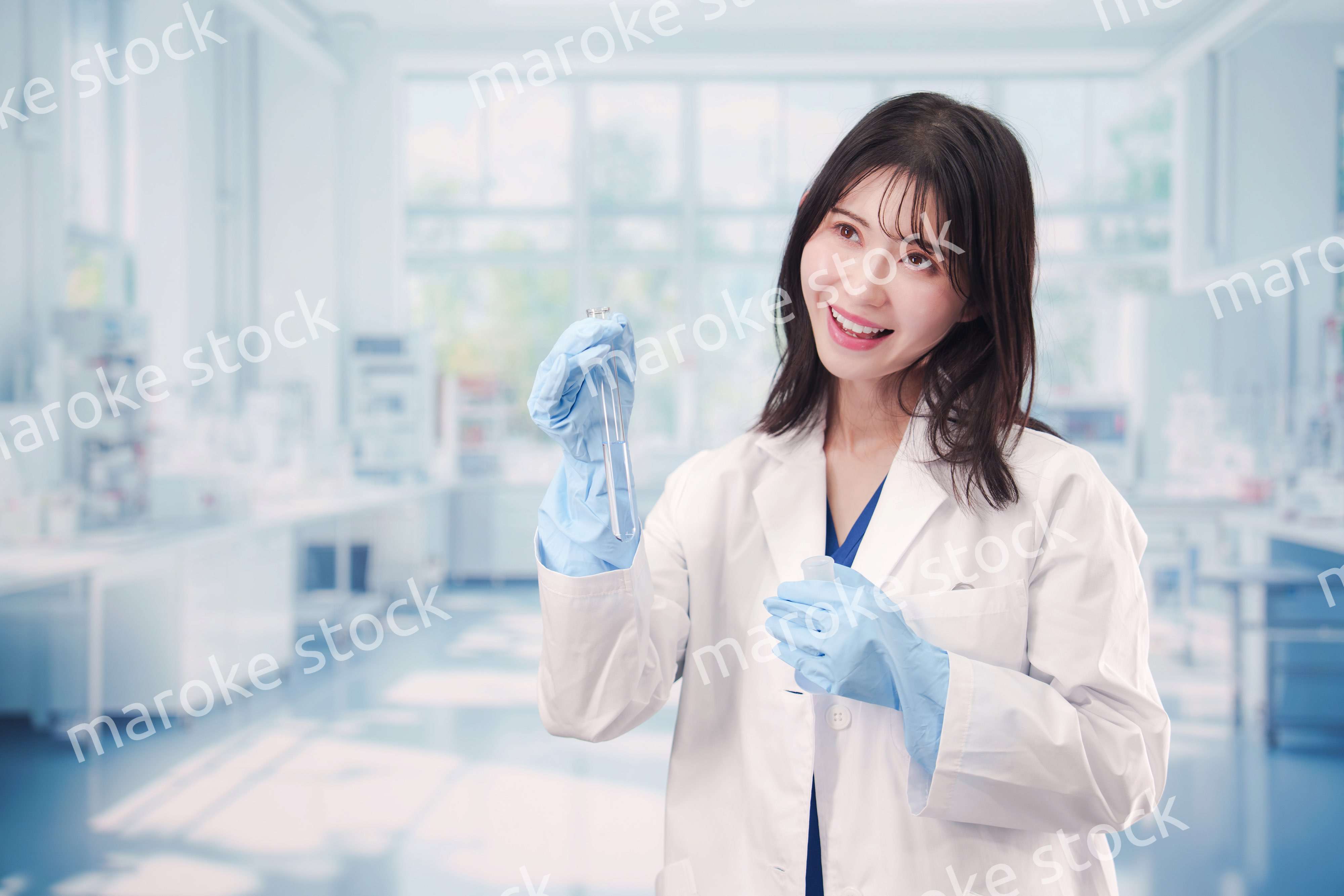 実験室で試験管の薬品を扱う若い女性