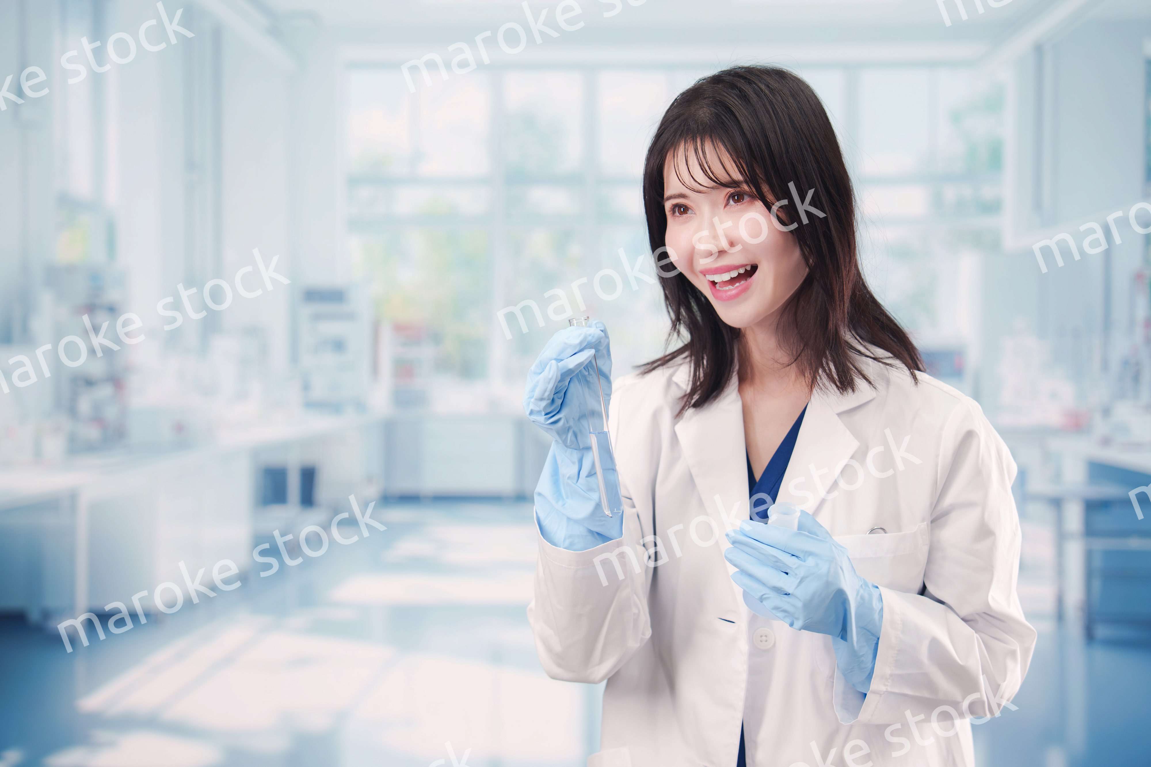 実験室で試験管の薬品を扱う若い女性