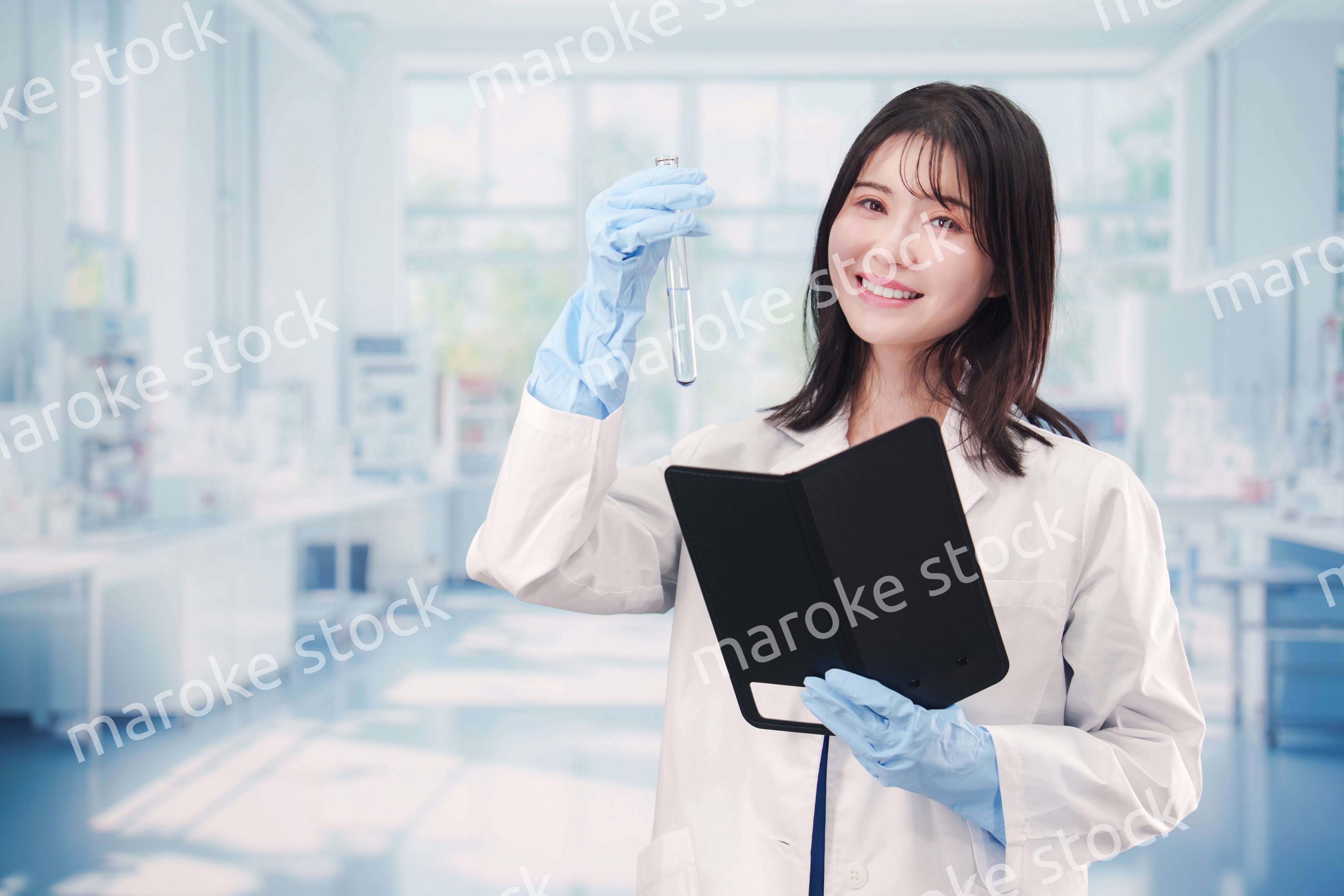 実験室で試験管の薬品を扱う若い女性