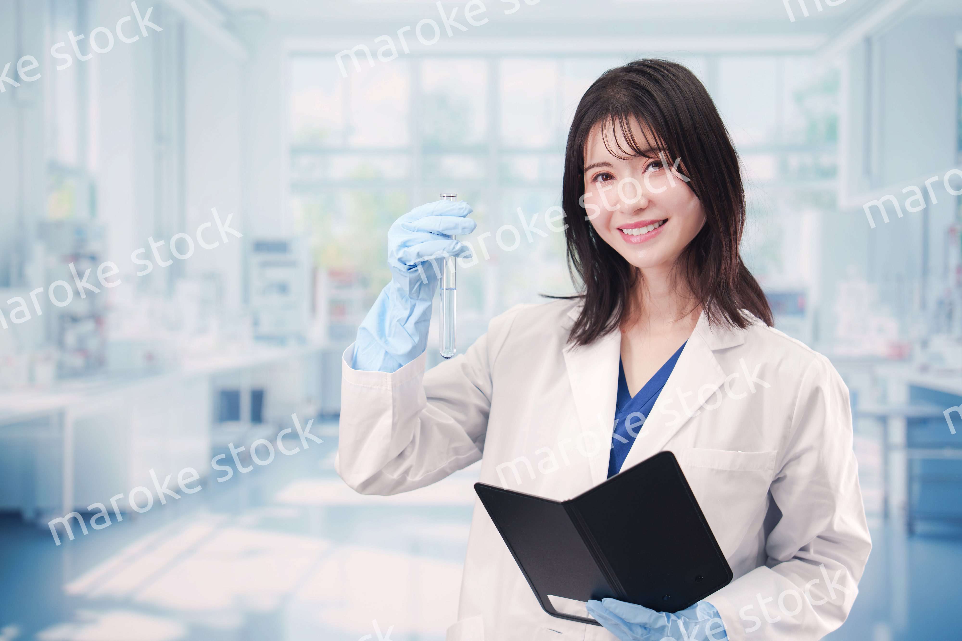 実験室で試験管の薬品を扱う若い女性