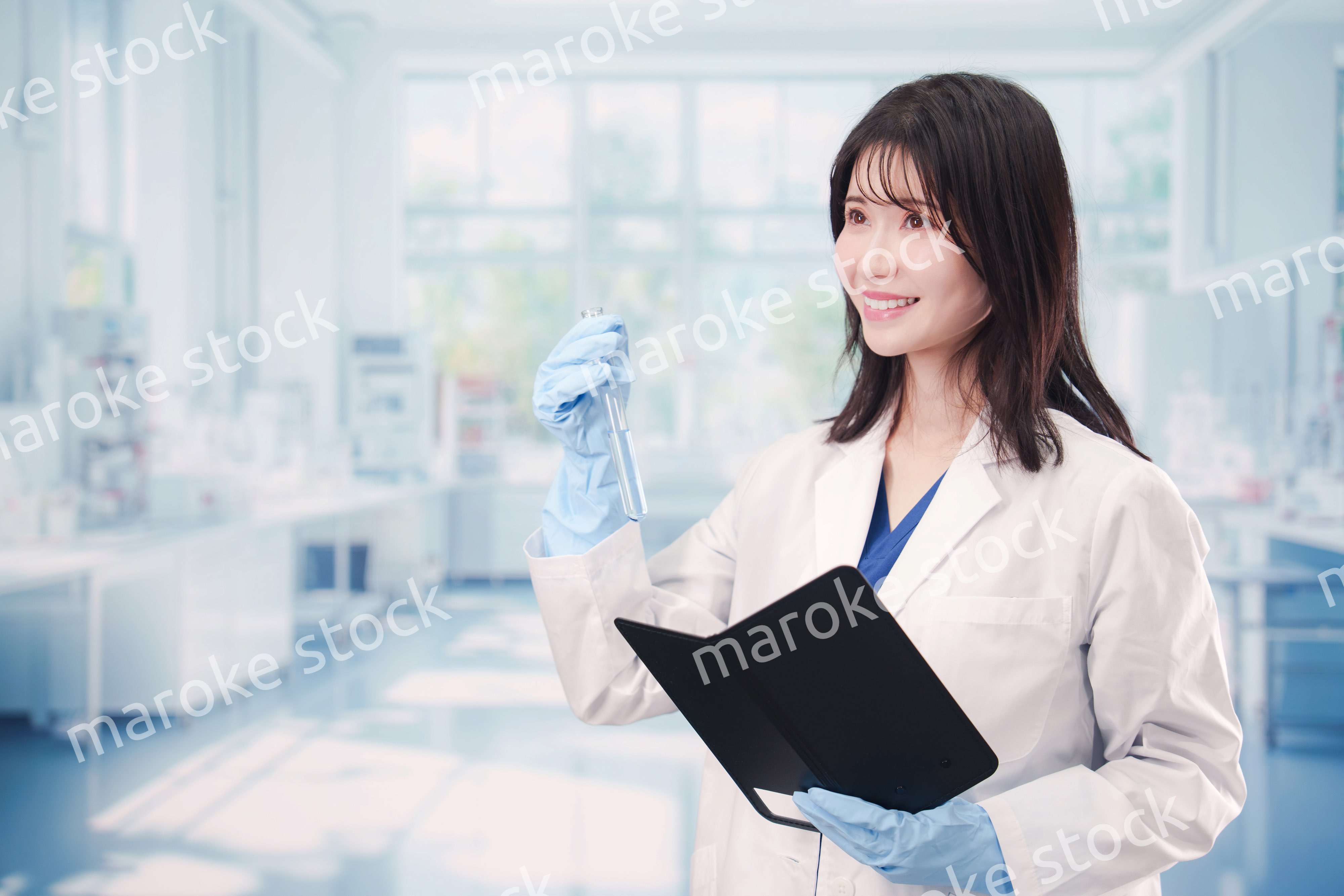 実験室で試験管の薬品を扱う若い女性