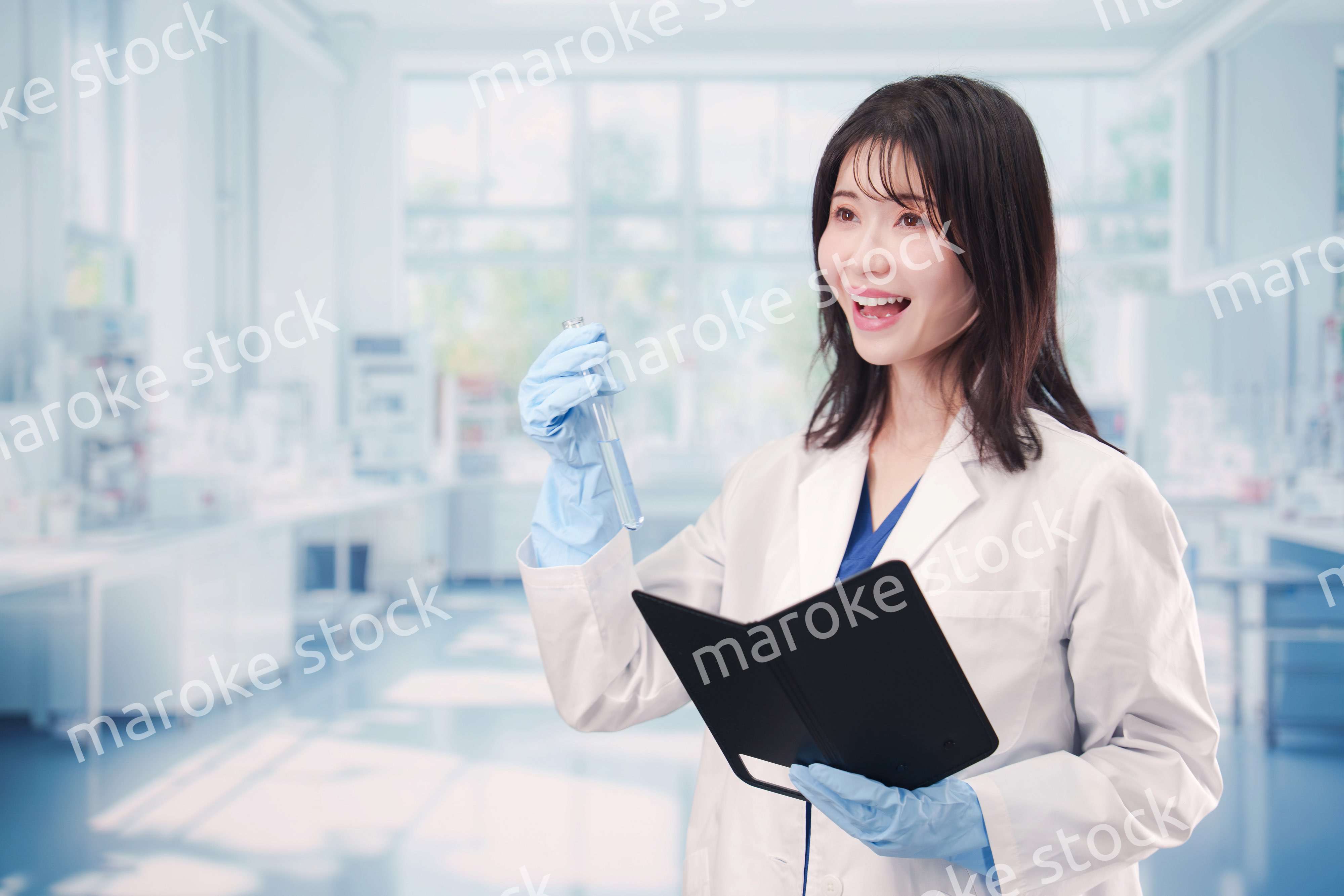 実験室で試験管の薬品を扱う若い女性