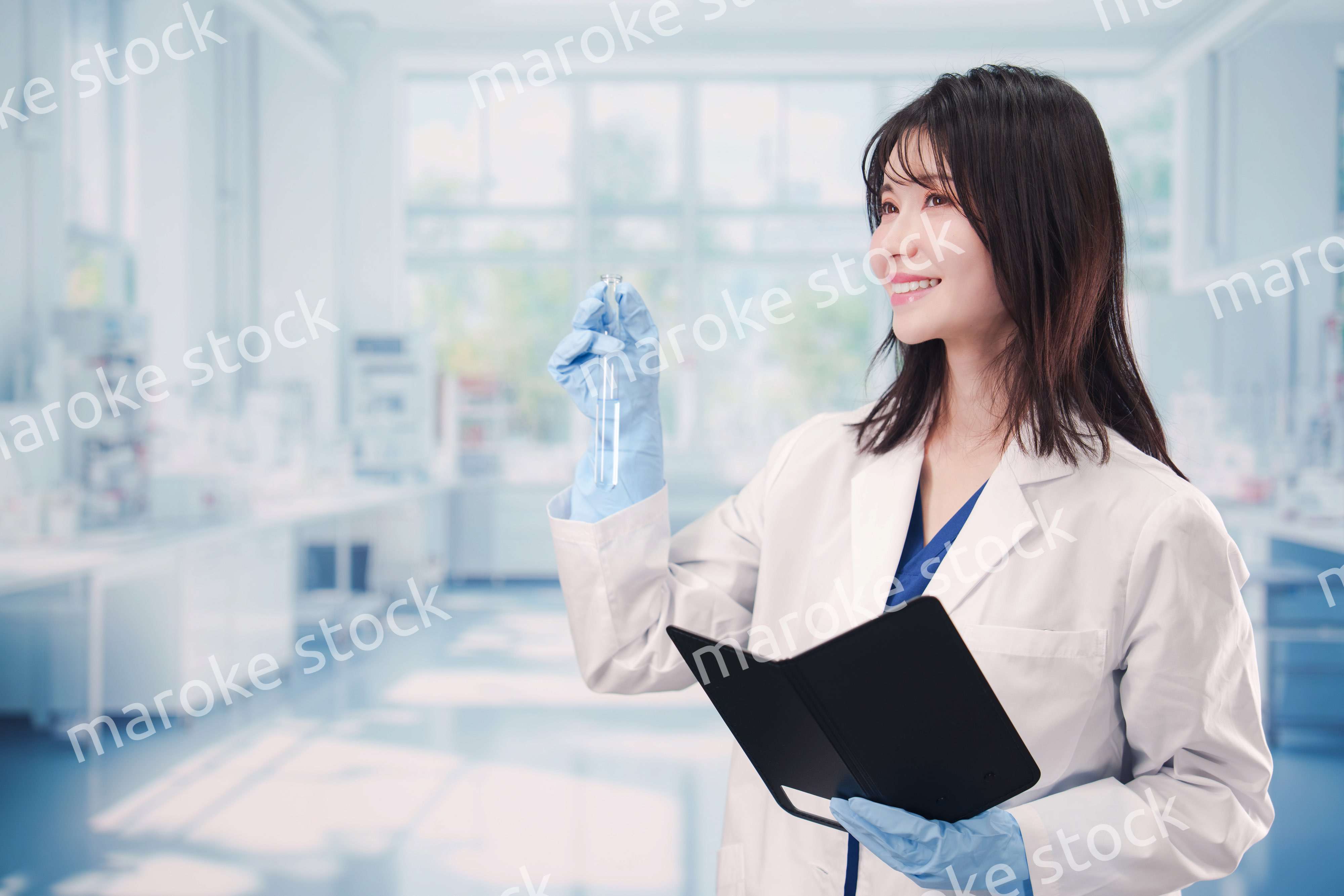 実験室で試験管の薬品を扱う若い女性