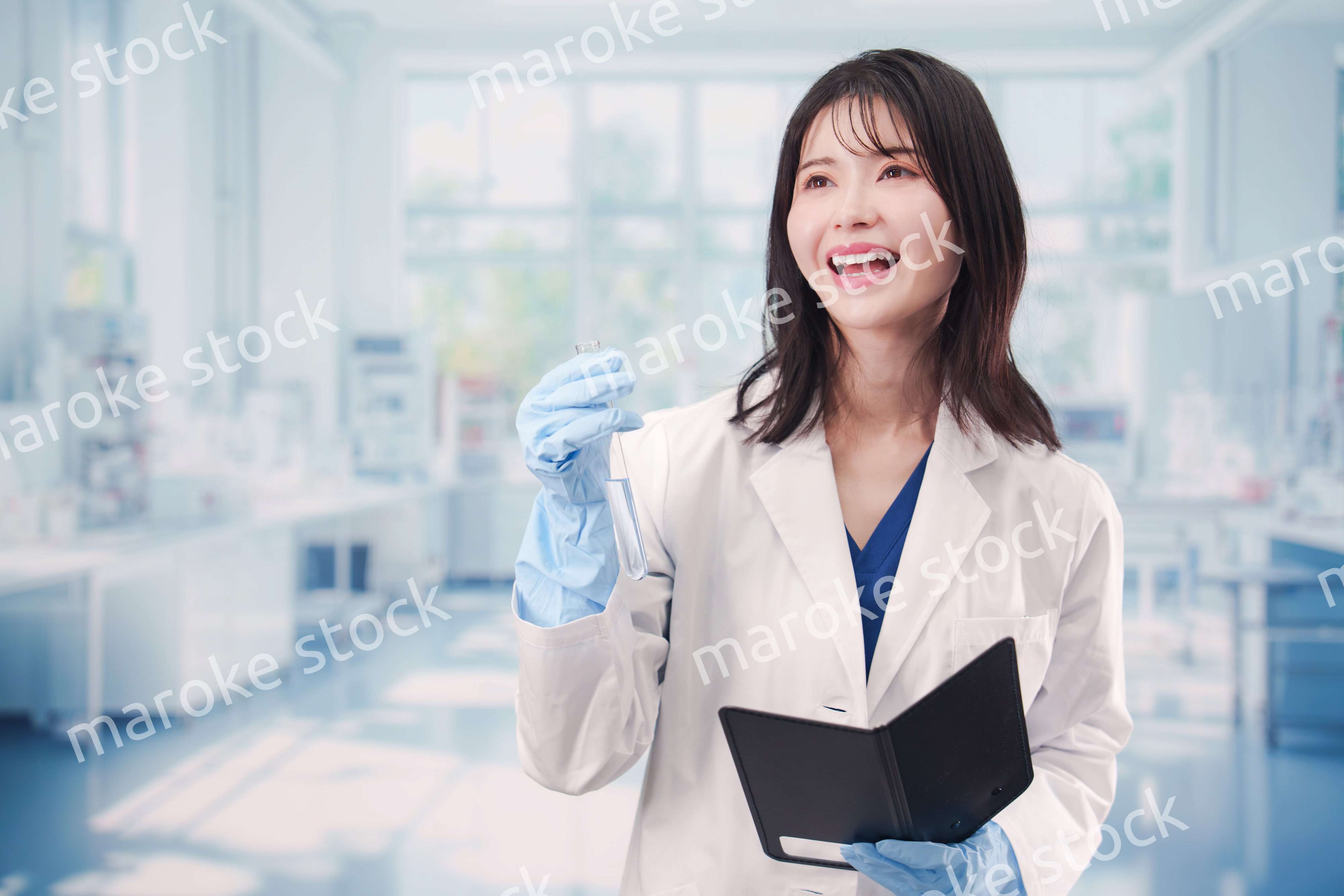 実験室で試験管の薬品を扱う若い女性