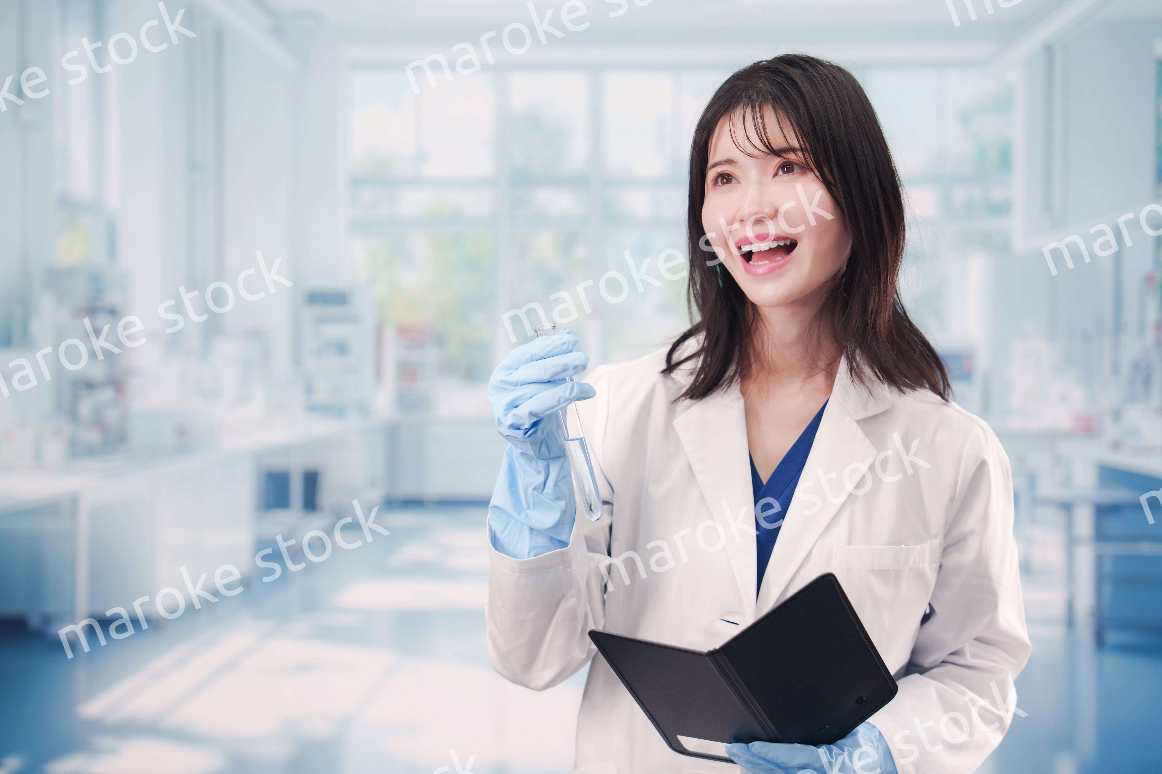 実験室で試験管の薬品を扱う若い女性