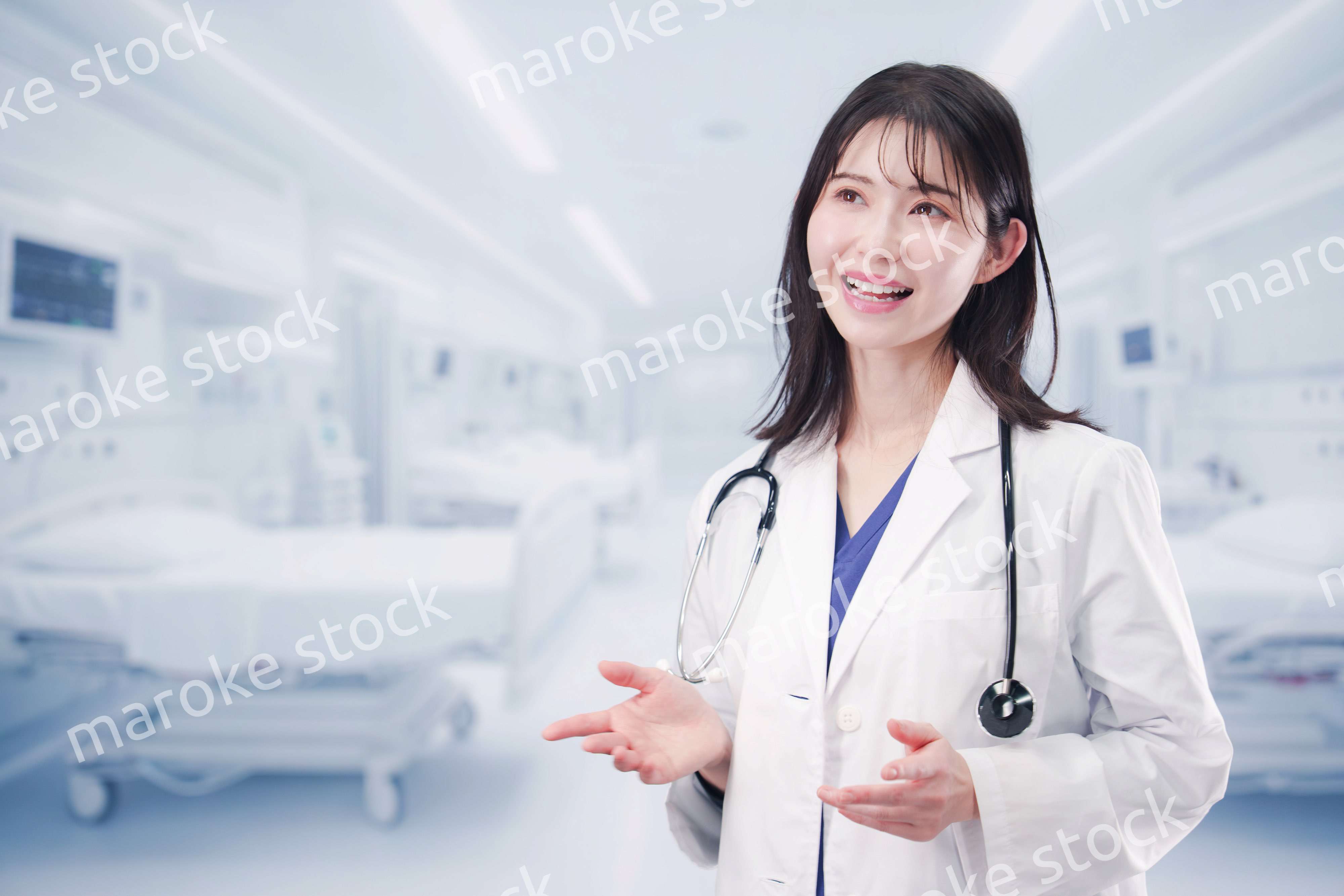 病院で患者に笑顔で説明をする女性ドクター