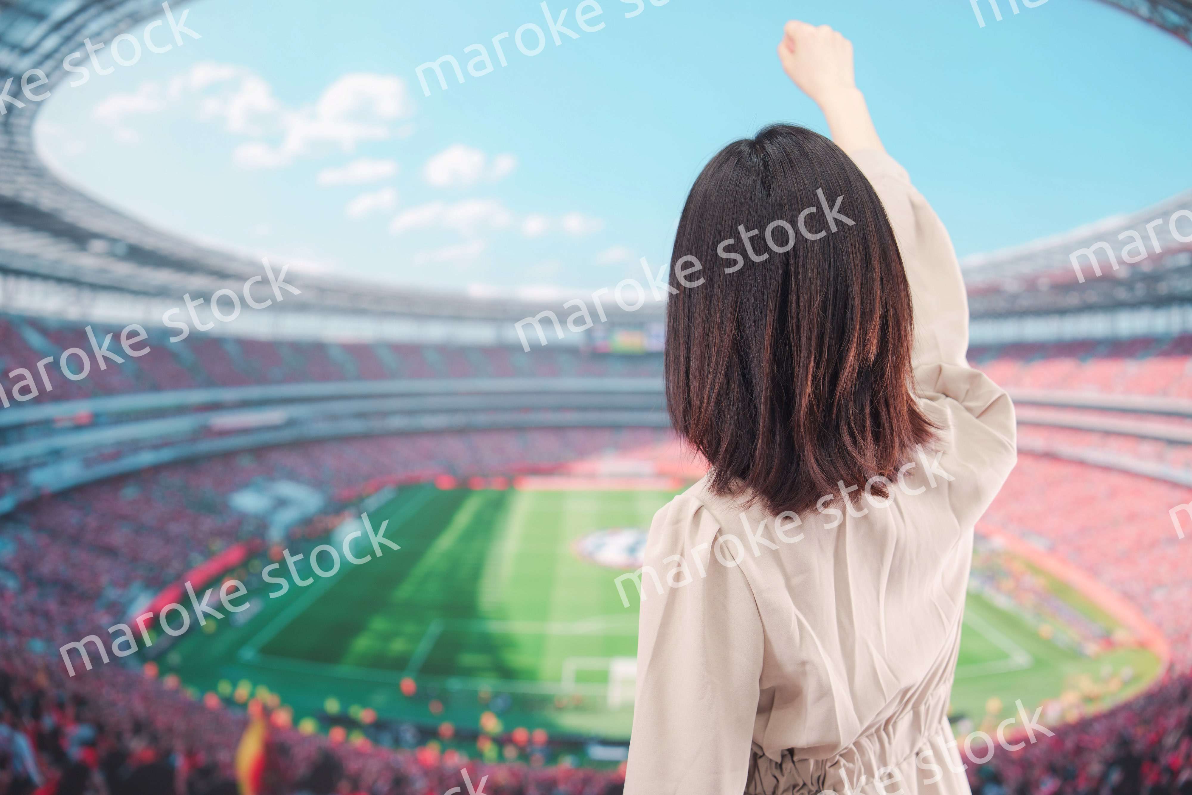 スタジアムで応援をする若い女性