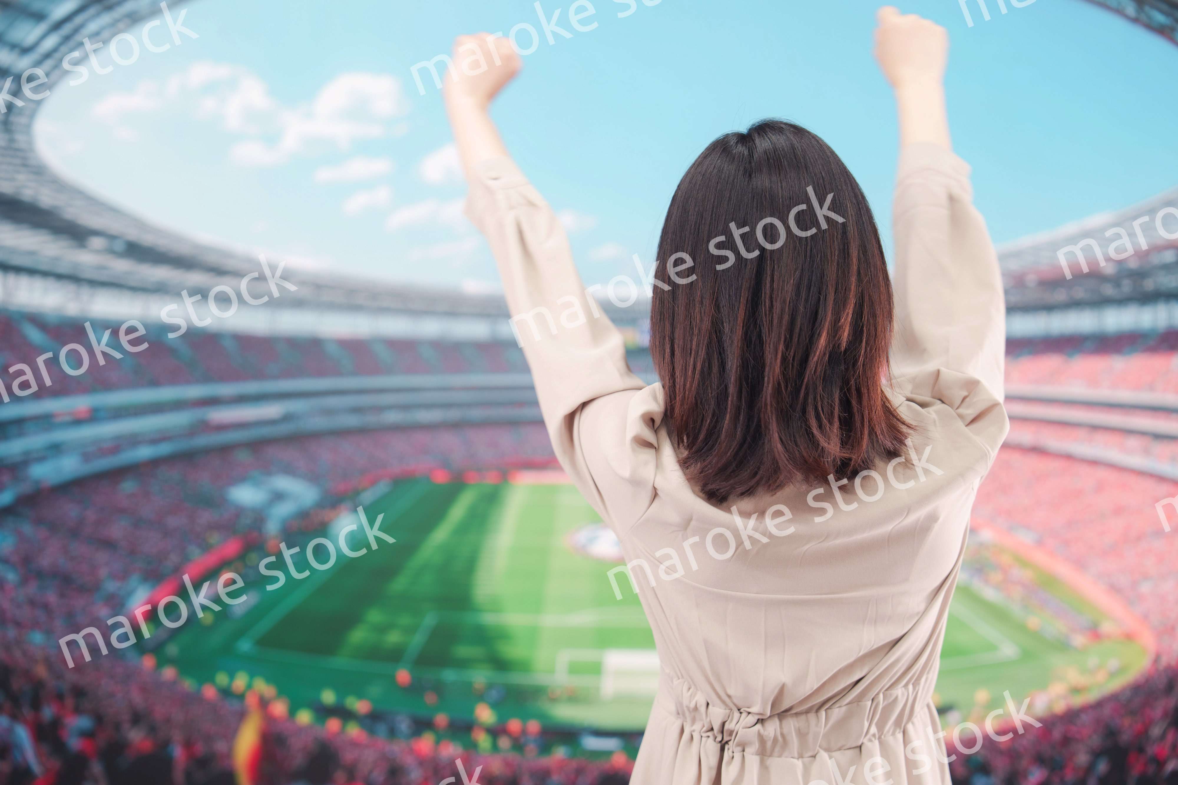 スタジアムで応援をする若い女性