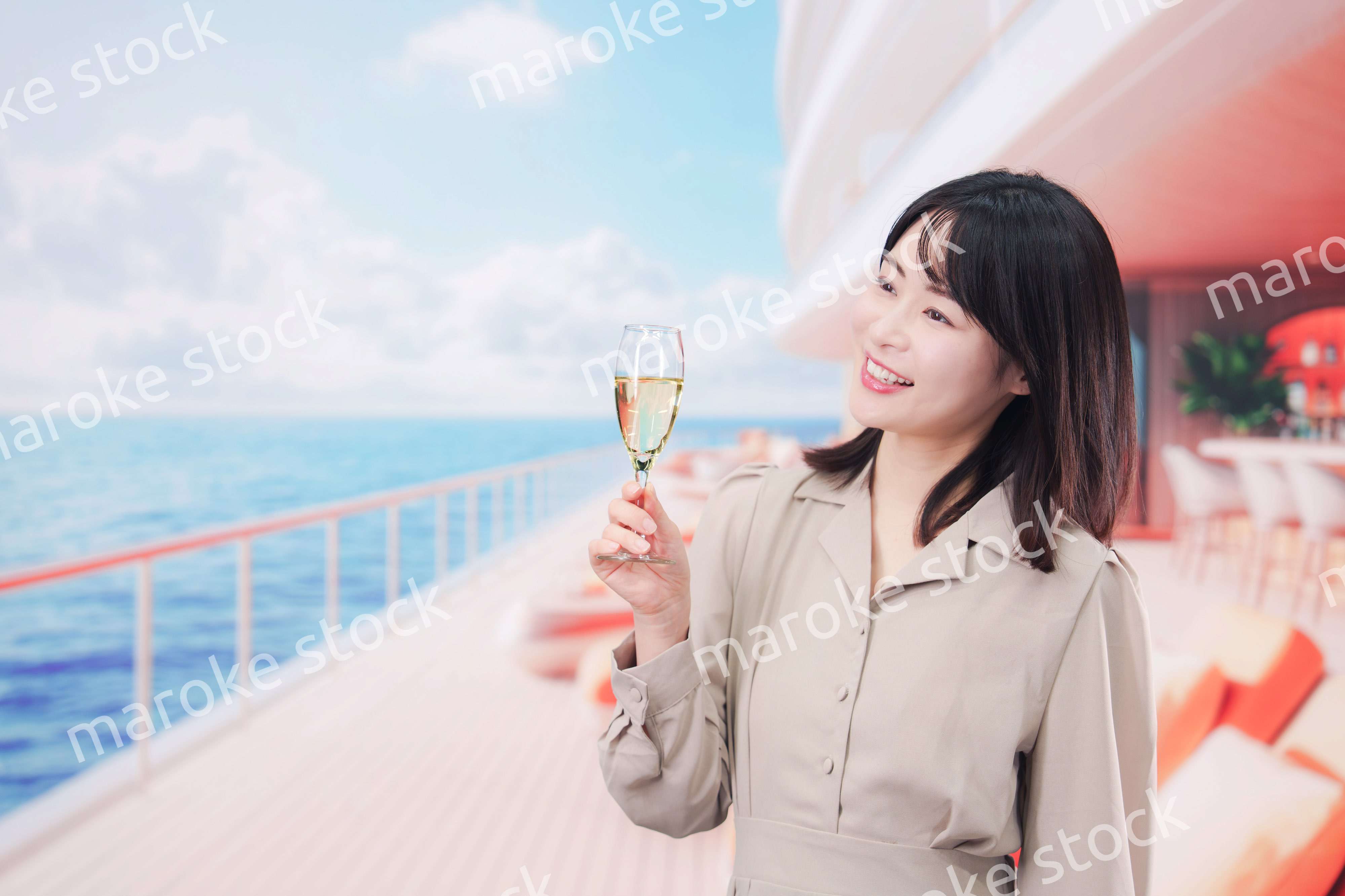 クルーズ船のデッキでスパークリングワインを飲む若い女性