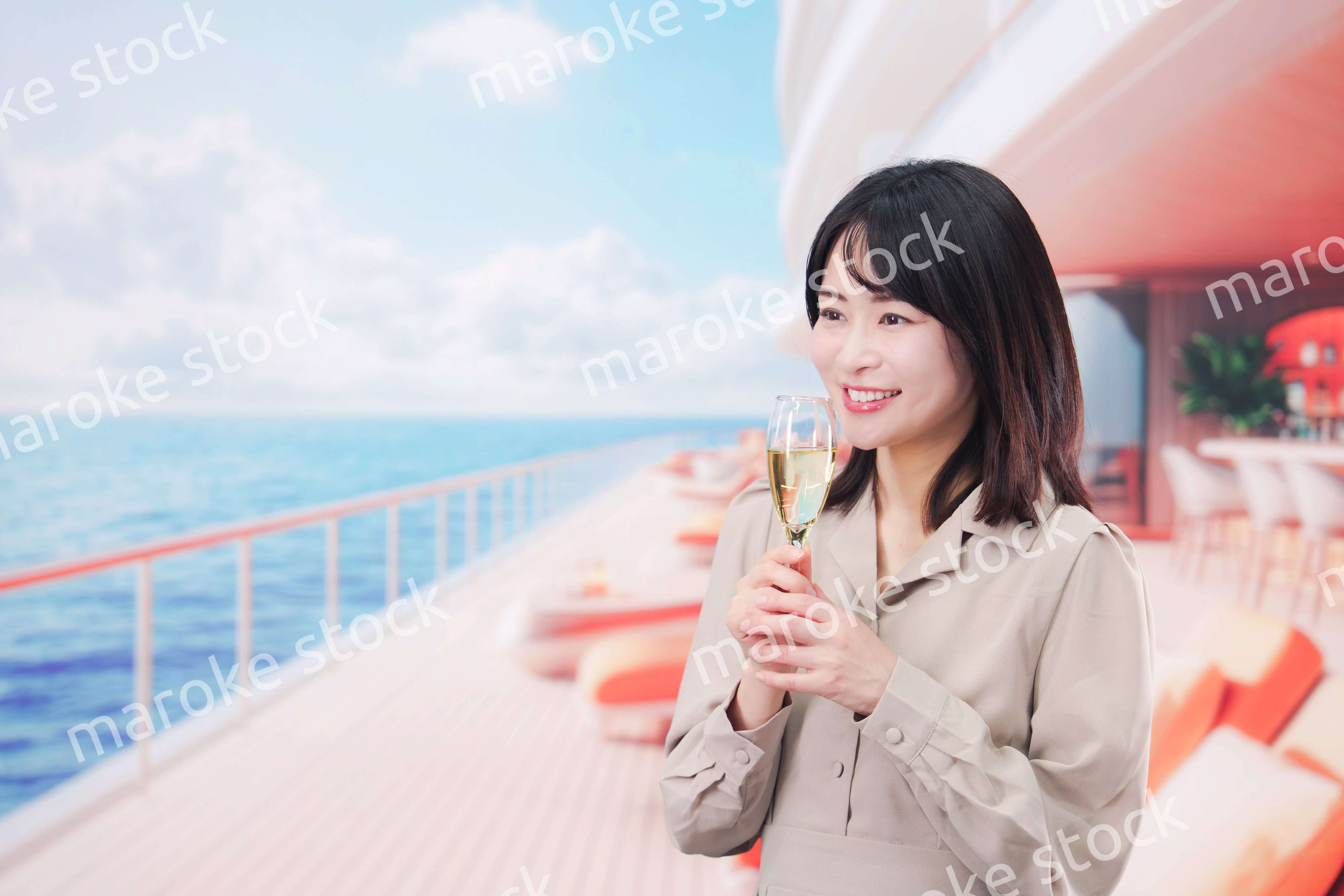 クルーズ船のデッキでスパークリングワインを飲む若い女性