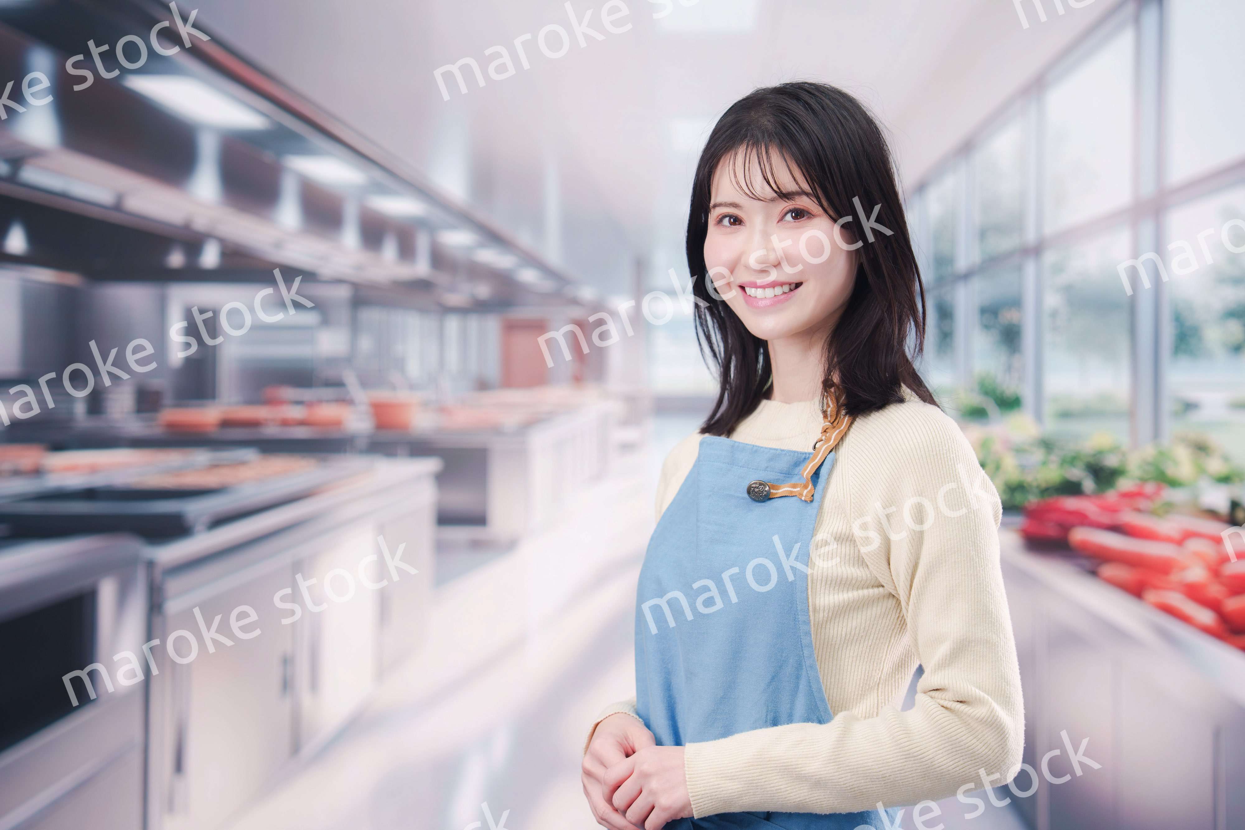 大きなキッチンで働く若い女性