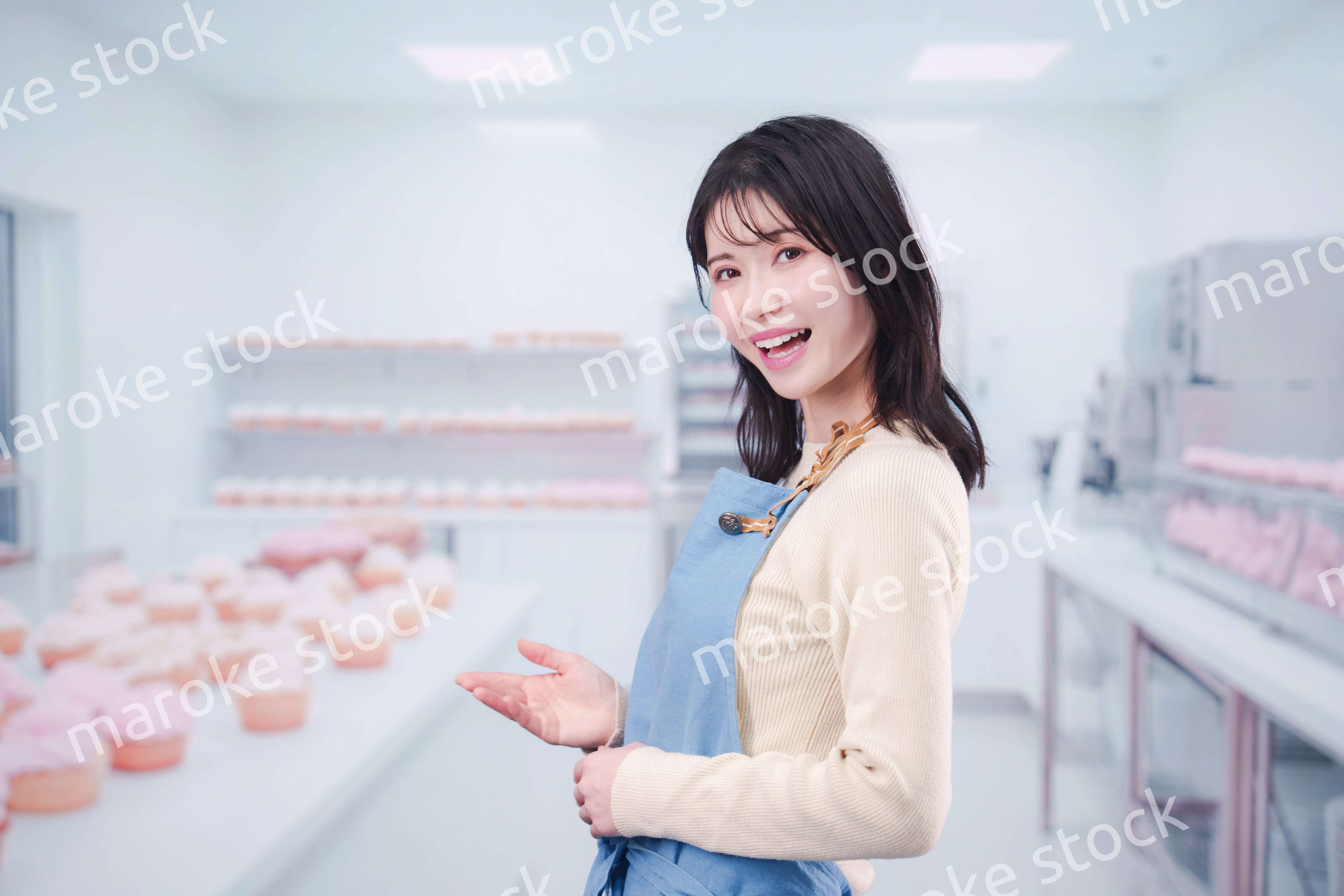 笑顔でお菓子作りをするパティシエの若い女性