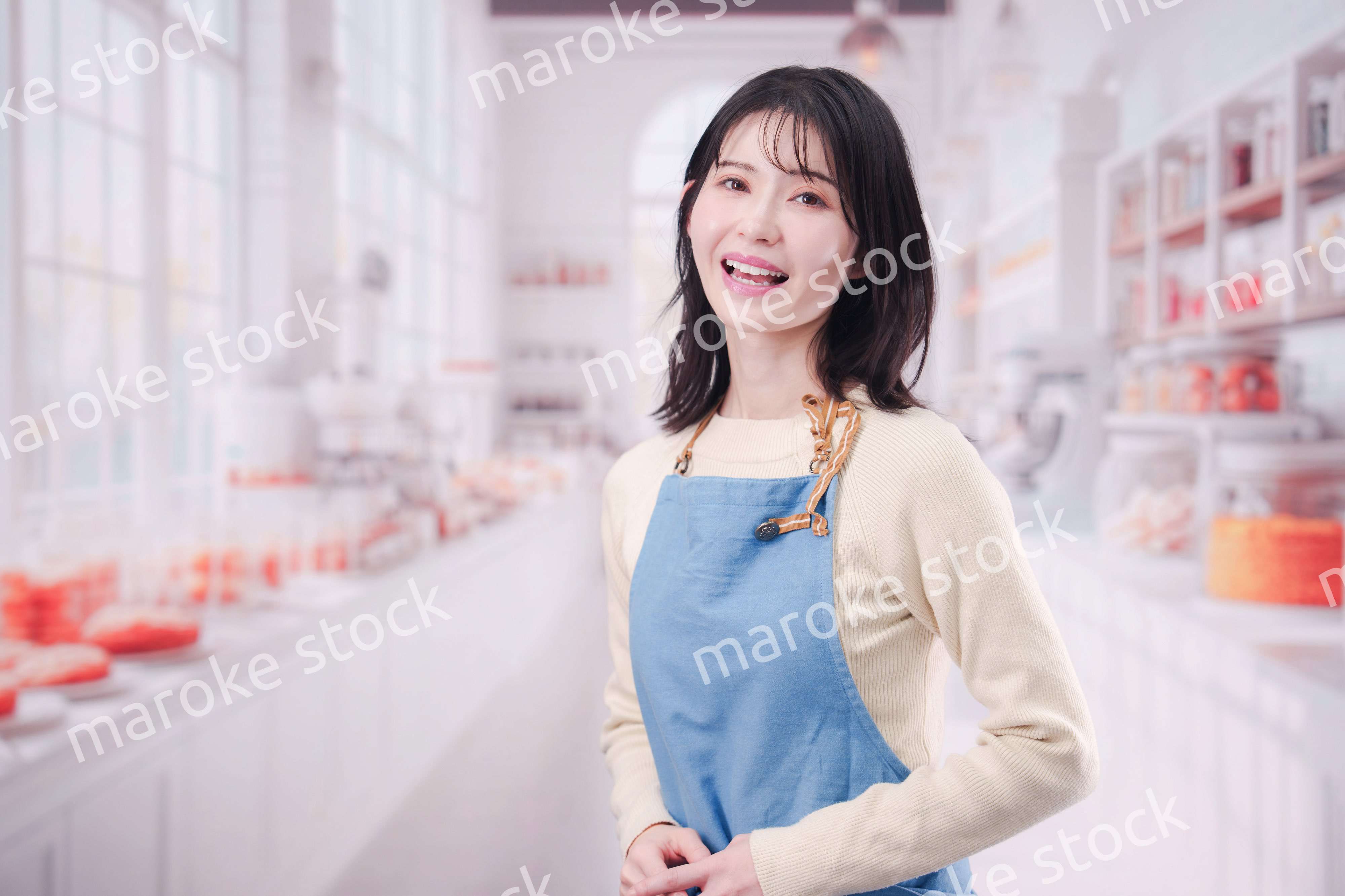 笑顔でお菓子作りをするパティシエの若い女性