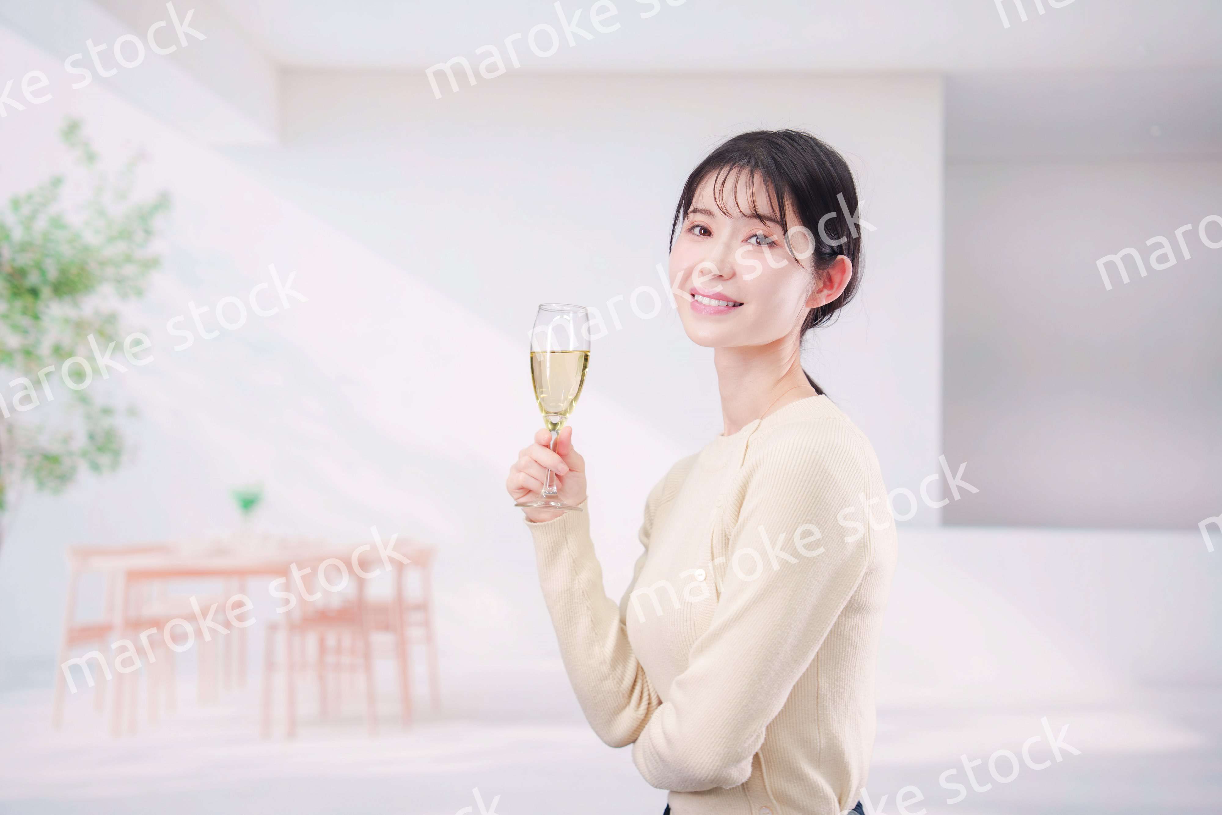 家でグラスワインを飲む若い女性