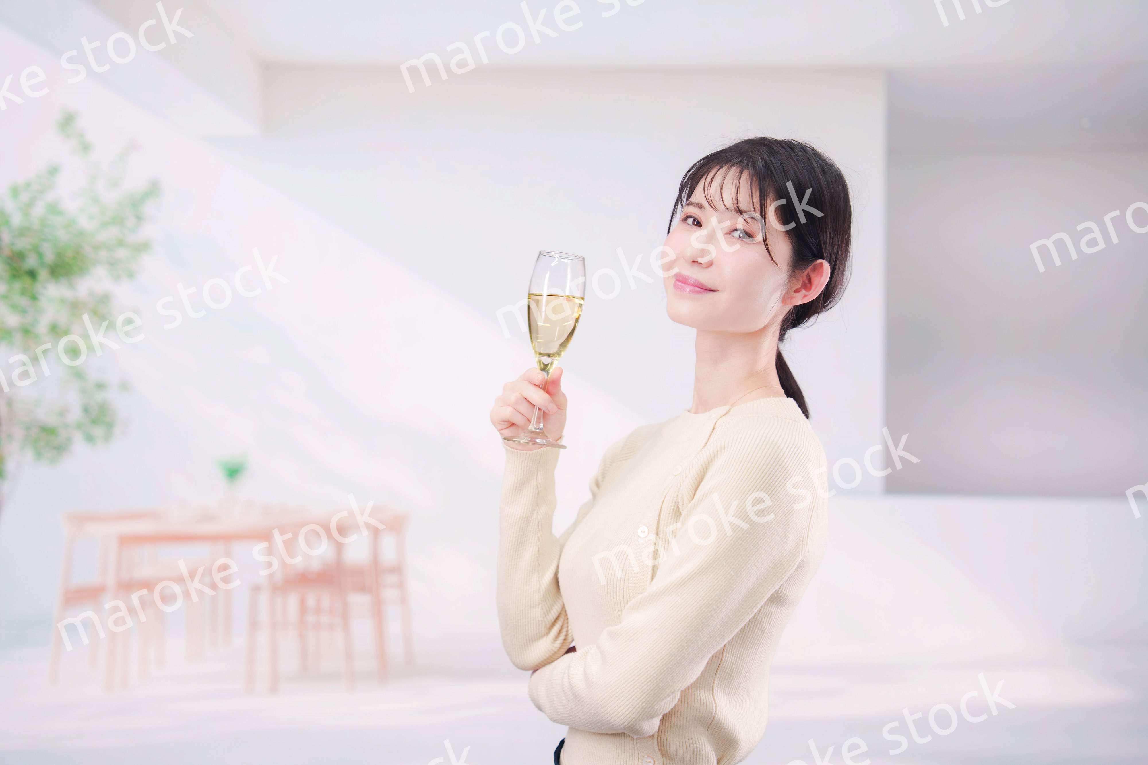 家でグラスワインを飲む若い女性