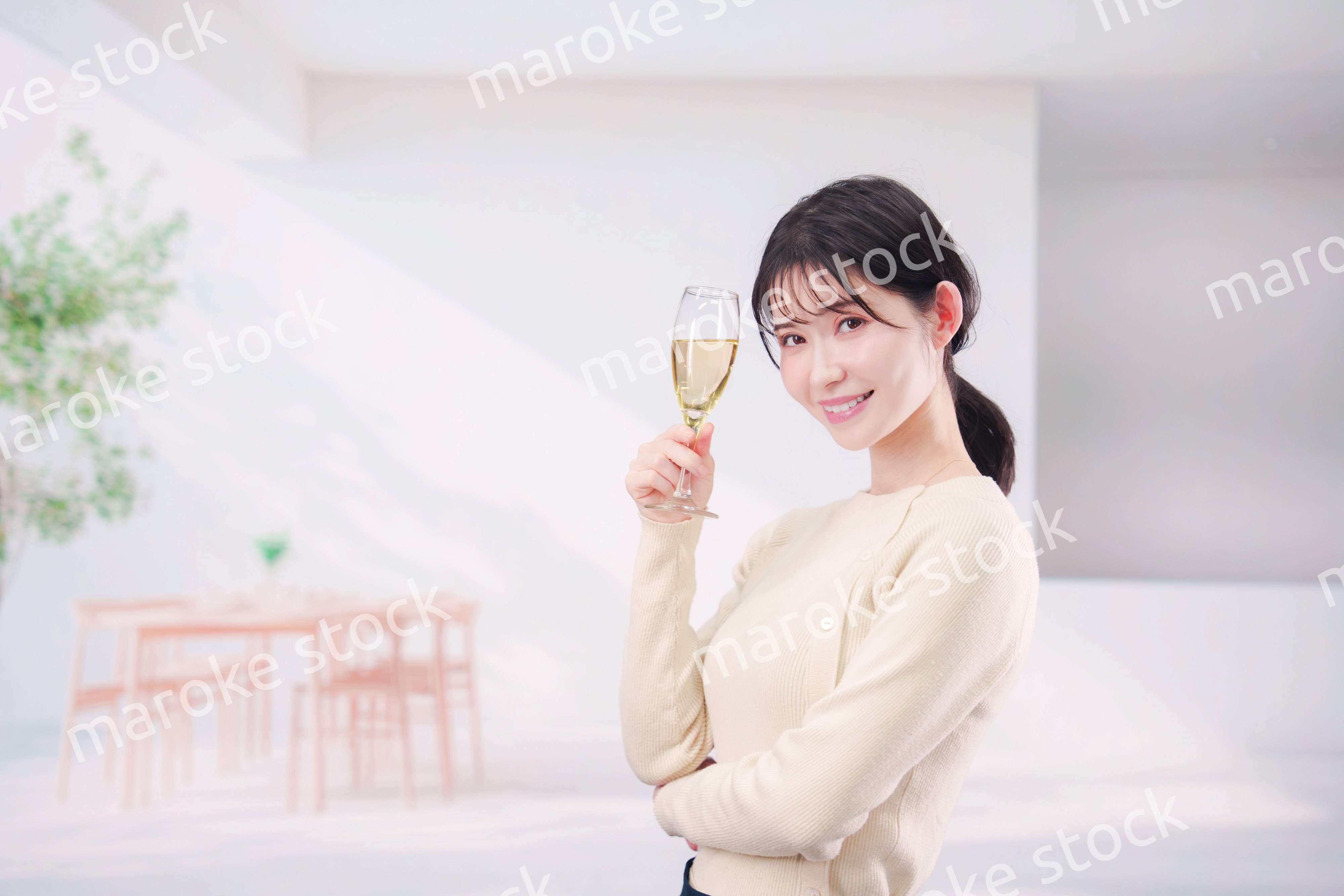 家でグラスワインを飲む若い女性