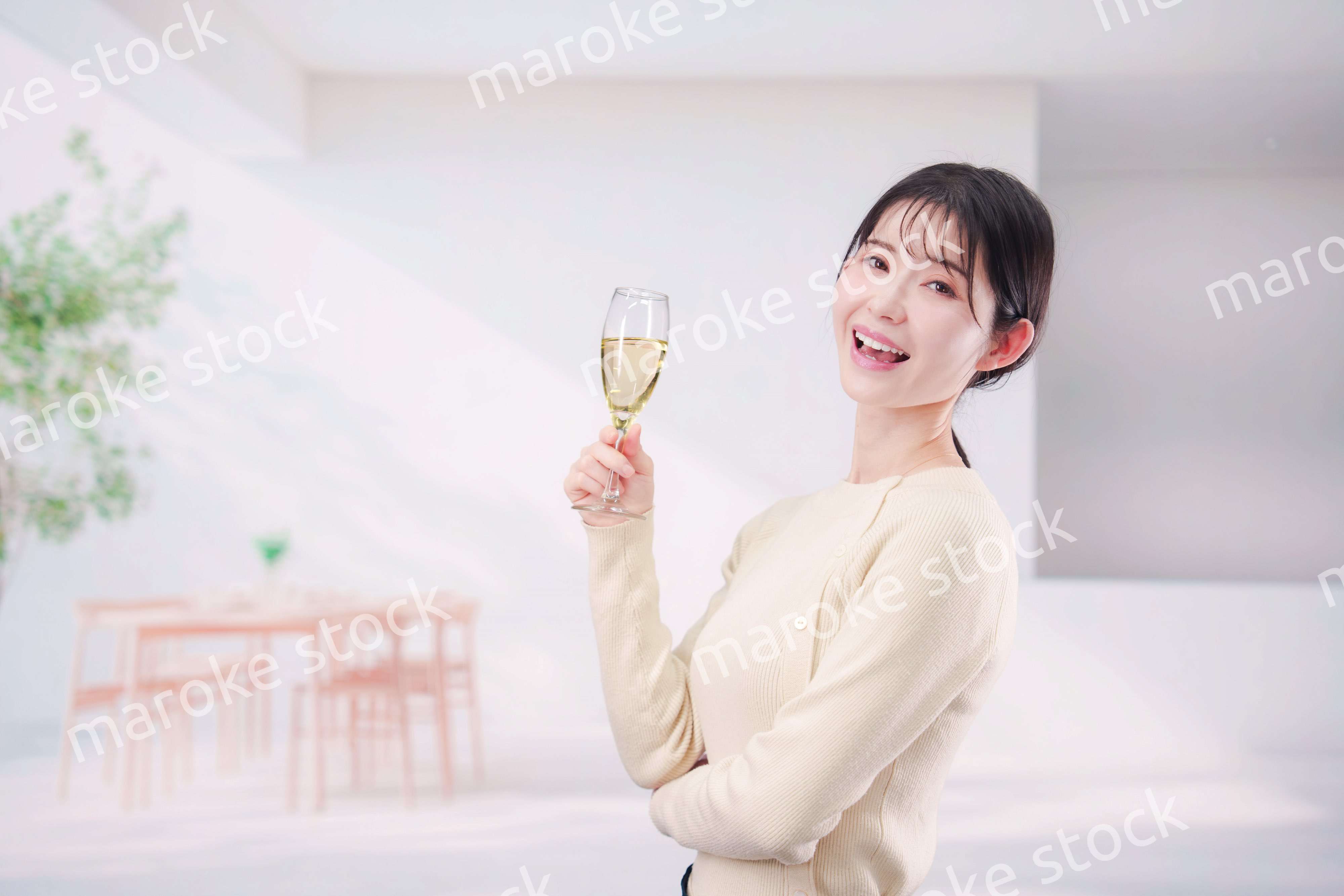 家でグラスワインを飲む若い女性